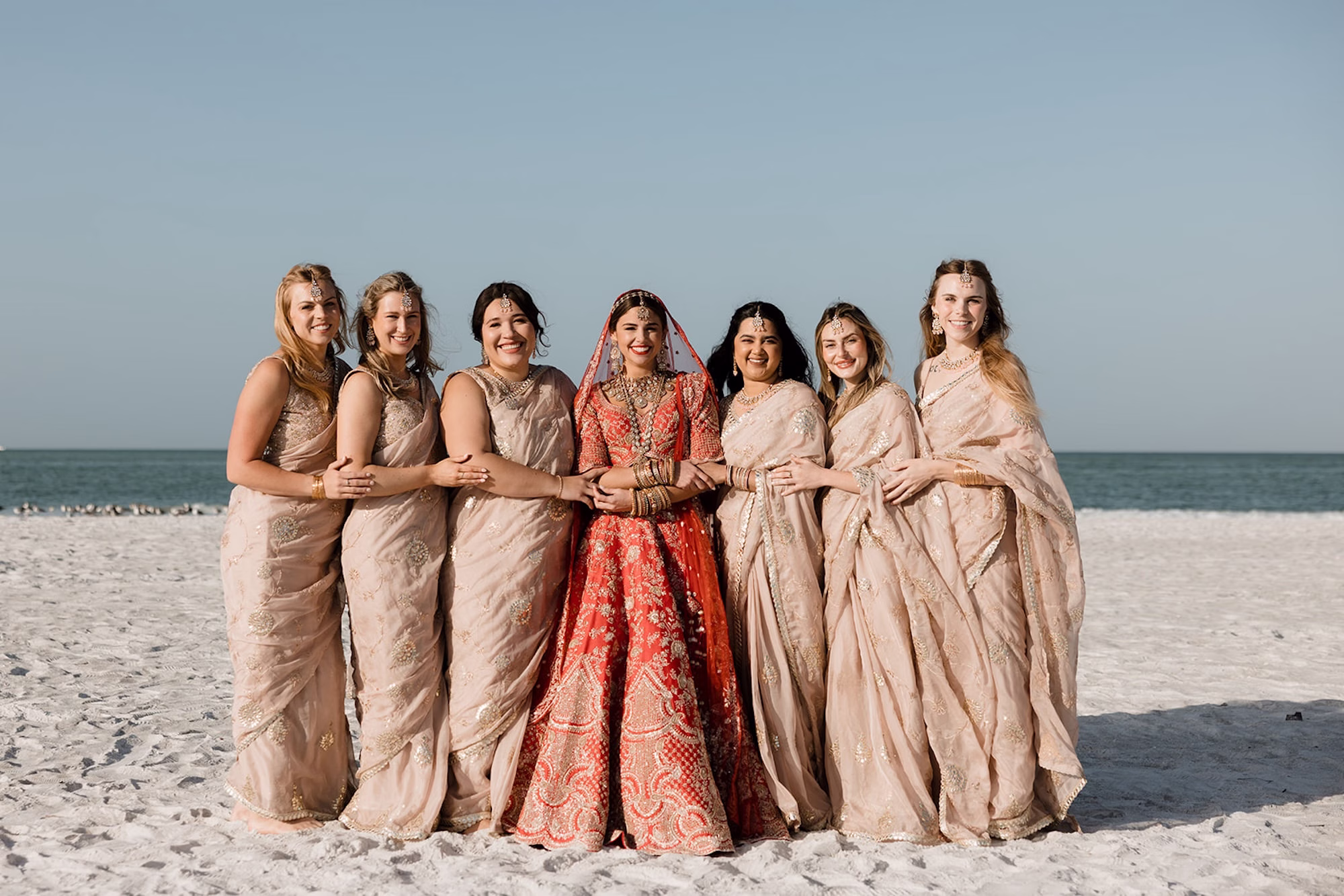 15Tropical Pink and Red Sarasota Beach Indian Wedding Ceremony - Vibrant Pink and Gold Multicultural Sarasota Wedding | Powel Crosley Estate Bride and Bridesmaids on Beach Wedding Portrait | Bright Red and Gold Bridal Lehenga by Kalighata at Kynah Ideas | Elegant Neutral Traditional Indian Gold Sarees, Lehenga Cholis Bridesmaid Dresses Inspiration | Photographer Evoke Photo and Film