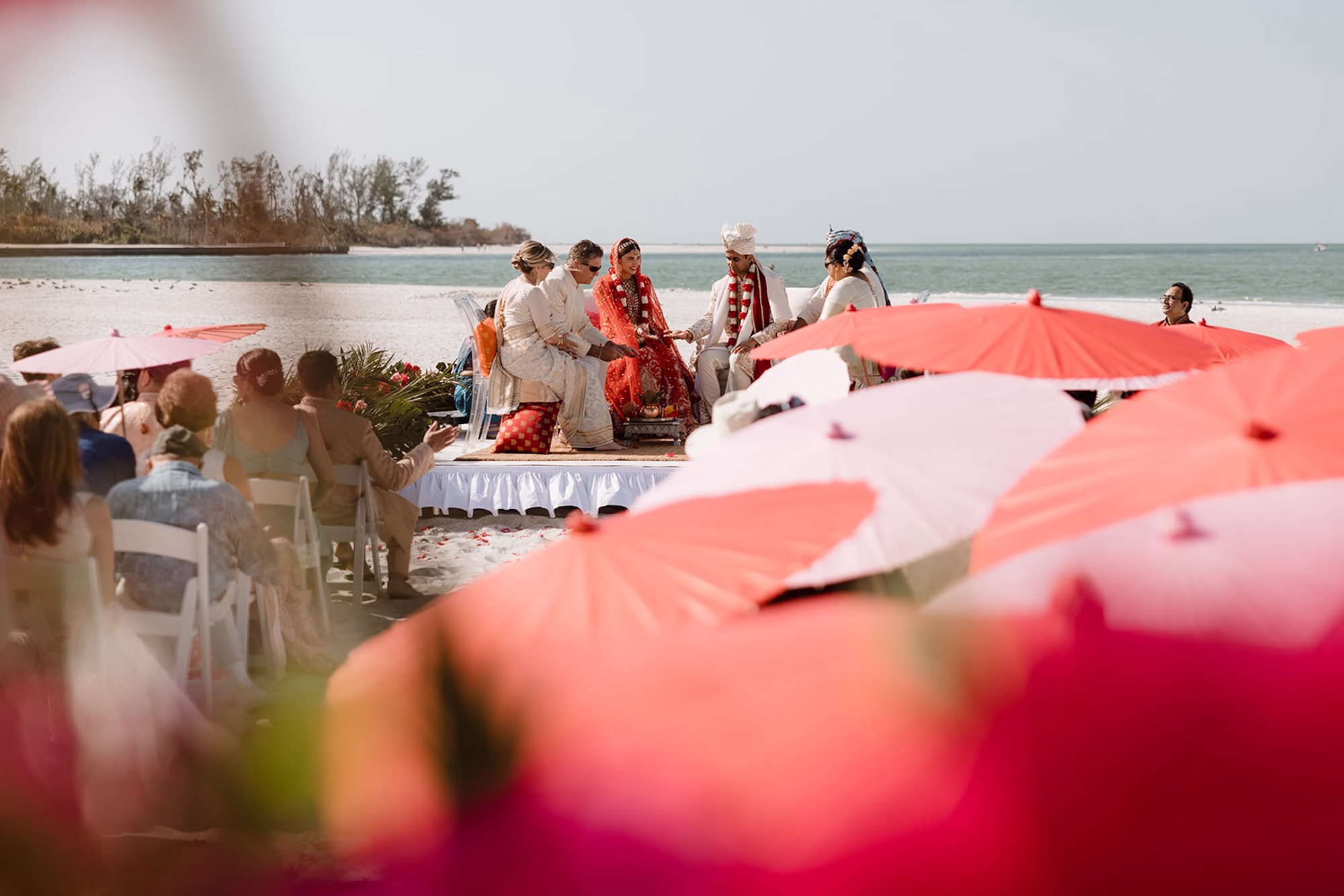 26Tropical Pink and Red Sarasota Beach Indian Wedding Ceremony - Vibrant Pink and Gold Multicultural Sarasota Wedding | Powel Crosley Estate Bride and Groom Traditional Indian Wedding Ceremony Wedding Portrait | Bright Red and Gold Bride Lehenga by Kalighata at Kynah Ideas | Groom Beaded Off-White Sherwani Inspiration | Indian Culture Wedding Ideas | Sarasota Beach Event Venue The Resort at Longboat Key Club | Photographer Evoke Photo and Film