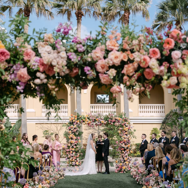 Bride and Groom Wedding Ceremony Vow Exchange Wedding Portrait | Outdoor Whimsical Colorful Garden Wedding Ceremony Ideas | Vibrant Romantic Garden Floral Altar Arch of Pastel Blush, Pink, Cream, Peach, Lavender Roses, Peonies and Hydrangeas Floral Wedding Ceremony Decor Inspiration | Content Creator Behind The Vows | Event Venue Ritz Carlton Sarasota | Tampa Bay Planner MDP Events