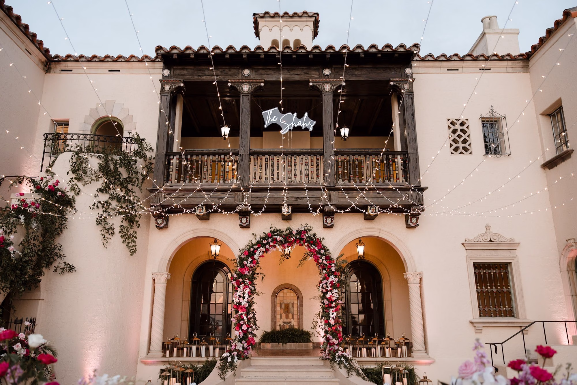 76Romantic Pink and Gold Waterfront Florida Wedding Sarasota Venue Powel Crosley Estate - Vibrant Pink and Gold Multicultural Sarasota Wedding | Powel Crosley Estate Garden Romantic Nighttime Outdoor Wedding Reception | Lush Full-Length Floral Arch with Pink, Red and Blush Roses, Hydrangeas and Greenery Reception Decor Inspiration | String Lights and Candlelit Table Reception Decor Ideas | Tampa Bay Wedding Photographer Evoke Photo and Film | Sarasota Wedding Venue Powel Crosley Estate