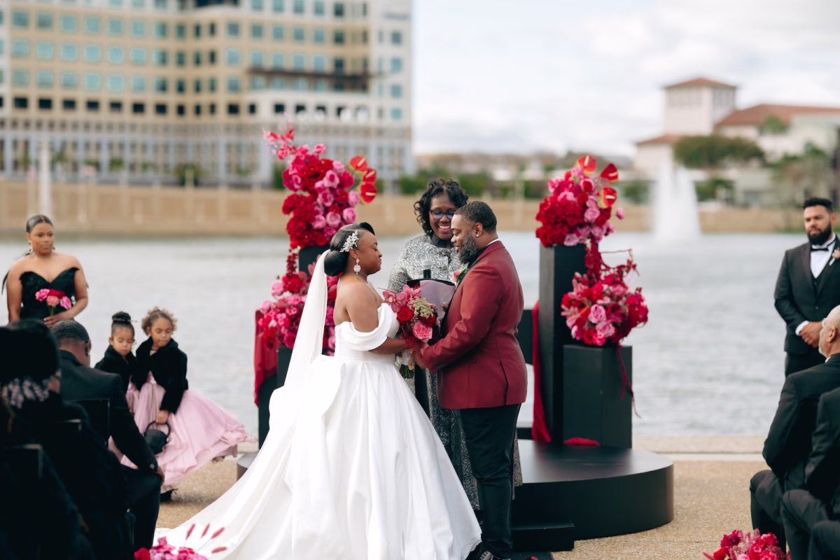 10Bold Pink Red and Burgundy Wedding Ideas - Glamorous, Burgundy Lakeland Wedding | Lake Mirror Amphitheater Bride and Groom Waterfront Wedding Ceremony Vow Exchange Wedding Portrait | Pink, Red, Burgundy Wedding Ceremony Floral Decor Ideas | White Ball Gown with Long Train Inspiration | Lakeland Wedding Ceremony Venue Lake Mirror Amphitheater