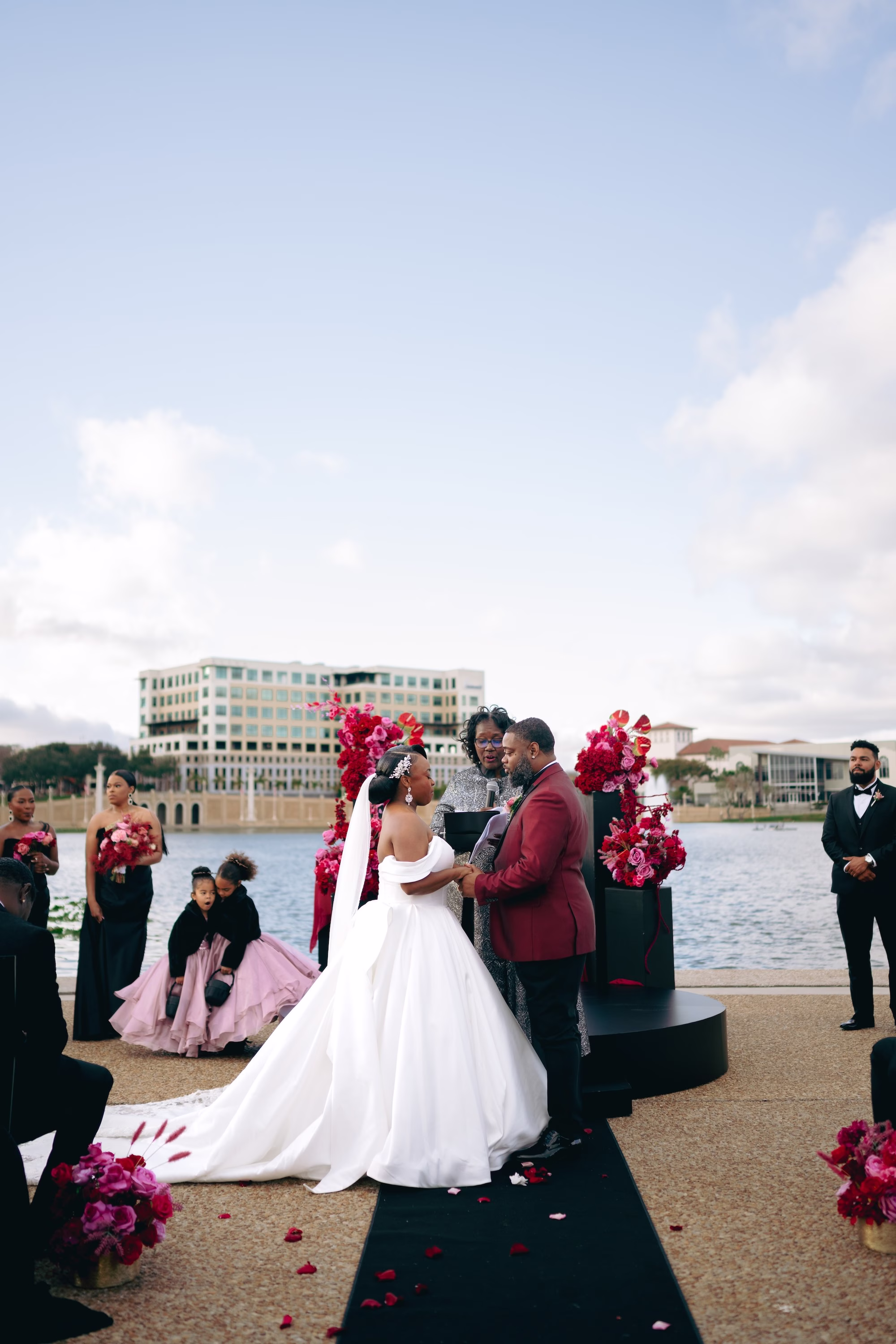 11Bold Pink Red and Burgundy Wedding Ideas Lakeland Wedding Venue Lake Mirror Amphitheater - Glamorous, Burgundy Lakeland Wedding | Lake Mirror Amphitheater Bride and Groom Waterfront Wedding Ceremony Vow Exchange Wedding Portrait | Pink, Red, Burgundy Wedding Ceremony Floral Decor Ideas | White Ball Gown with Long Train Inspiration | Lakeland Wedding Ceremony Venue Lake Mirror Amphitheater