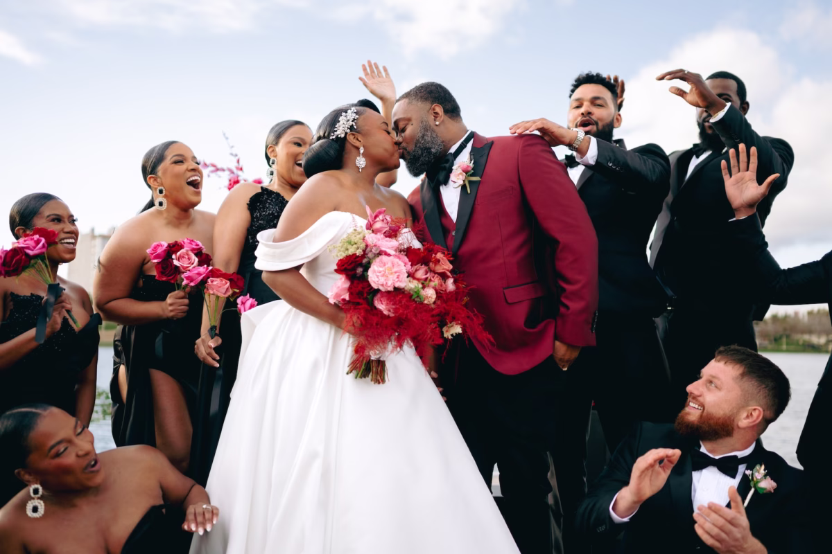 18Bold Pink Red and Burgundy Wedding Ideas - Glamorous, Burgundy Lakeland Wedding | Lake Mirror Amphitheater Bride and Groom Just Married Kiss with Wedding Party | Black Strapless Bridesmaid Dresses Inspiration | Hot Pink, Blush, Red and Burgundy Rose Floral Bouquet Ideas