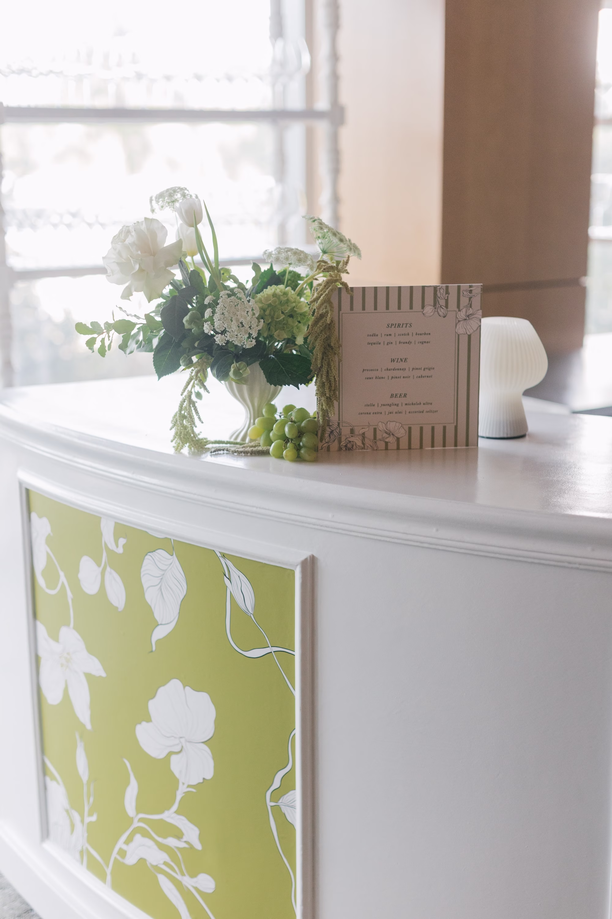 Elegant White and Green Traditional Jewish Wedding Reception Ceremony Decor Ideas | White and Green Floral Patterned Bar with White Linen Runner Wedding Reception Welcome Sign Inspiration | Lush White, Cream, Green, Pale Purple Floral Arrangement Decor of Hydrangeas, Roses, Greenery Decor Ideas | St Pete Planner Stelloccasions Weddings and Events