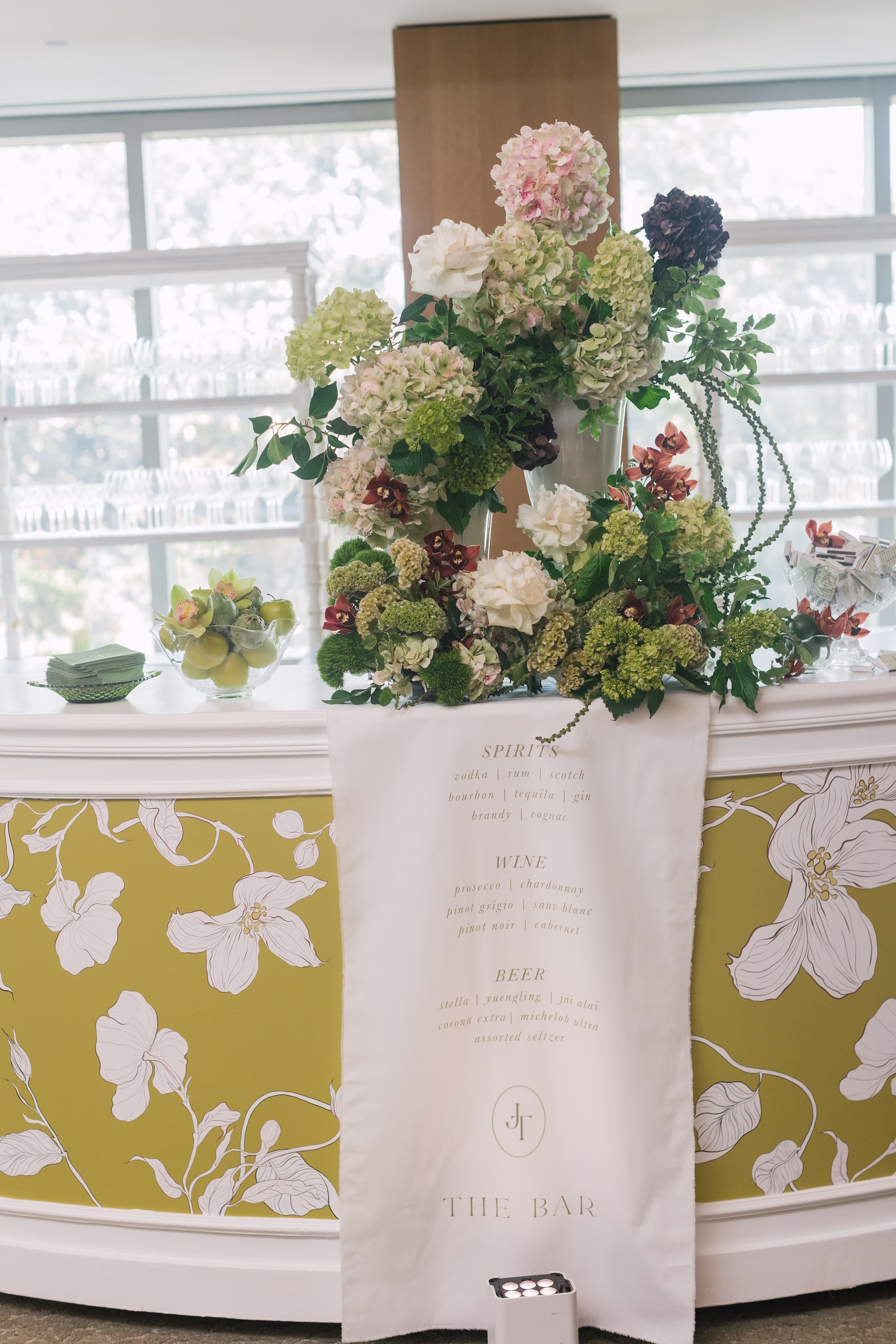 Elegant White and Green Traditional Jewish Wedding Reception Ceremony Decor Ideas | White and Green Floral Patterned Bar with White Linen Runner Wedding Reception Welcome Sign Inspiration | Lush White, Cream, Green, Pale Purple Floral Arrangement Decor of Hydrangeas, Roses, Greenery Decor Ideas | St Pete Planner Stelloccasions Weddings and Events