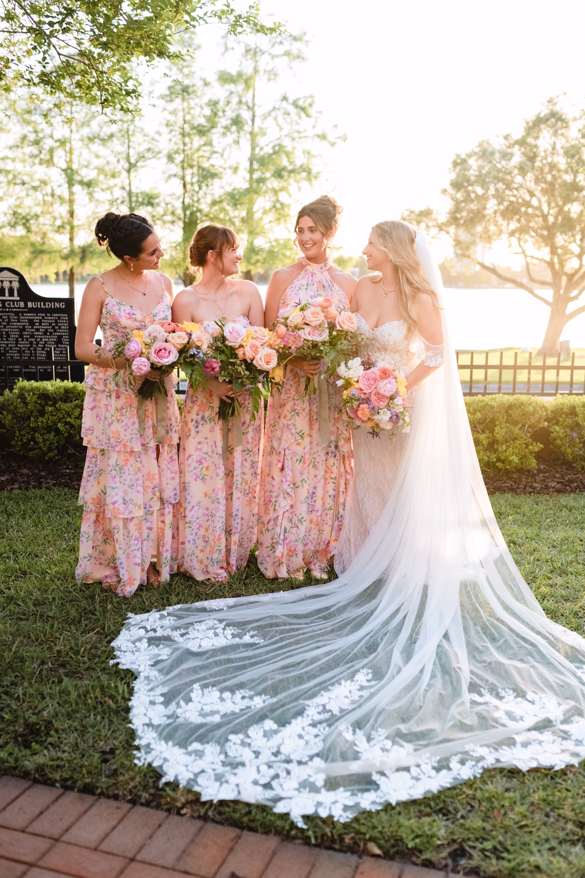 Bride and Bridesmaids Wedding Portrait | White Strapless Wedding Gown with Cathedral Length Floral Lace Trimmed Veil Inspiration | Mismatched Pink Pastel Floral Bridesmaids Dresses Ideas | Pastel Roses and Peonies Bouquet Inspiration | Tampa Boutique Truly Forever Bridal