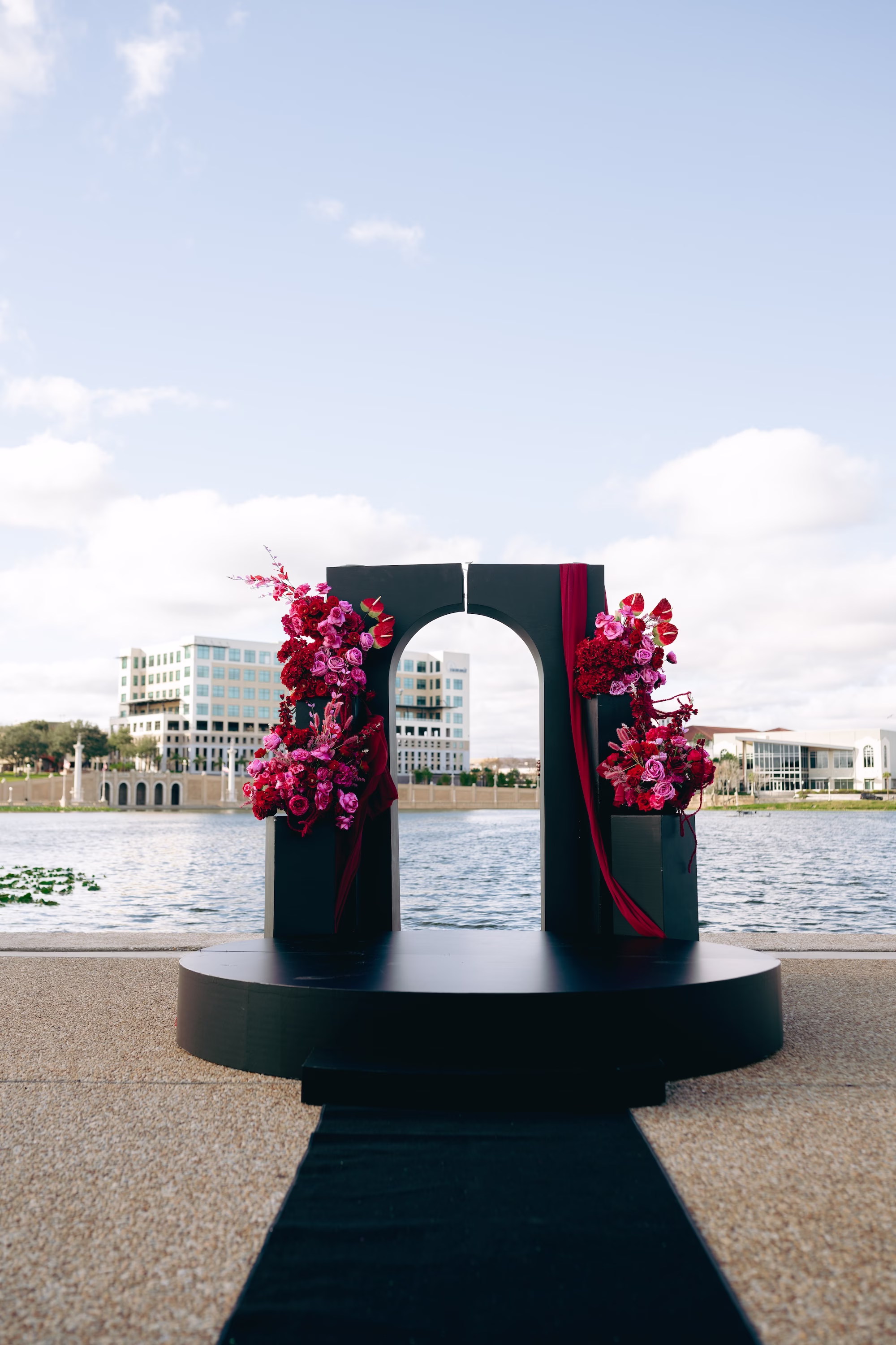 6Bold Pink Red and Burgundy Wedding Ideas Lakeland Wedding Venue Lake Mirror Amphitheater - Glamorous, Burgundy Lakeland Wedding | Lake Mirror Amphitheater Pink, Red, Burgundy Wedding Ceremony Floral Decor Ideas | Black Dual Pillar Archway and Black Altar Stage Wedding Ceremony Decor Inspiration | Lakeland Wedding Ceremony Venue Lake Mirror Amphitheater