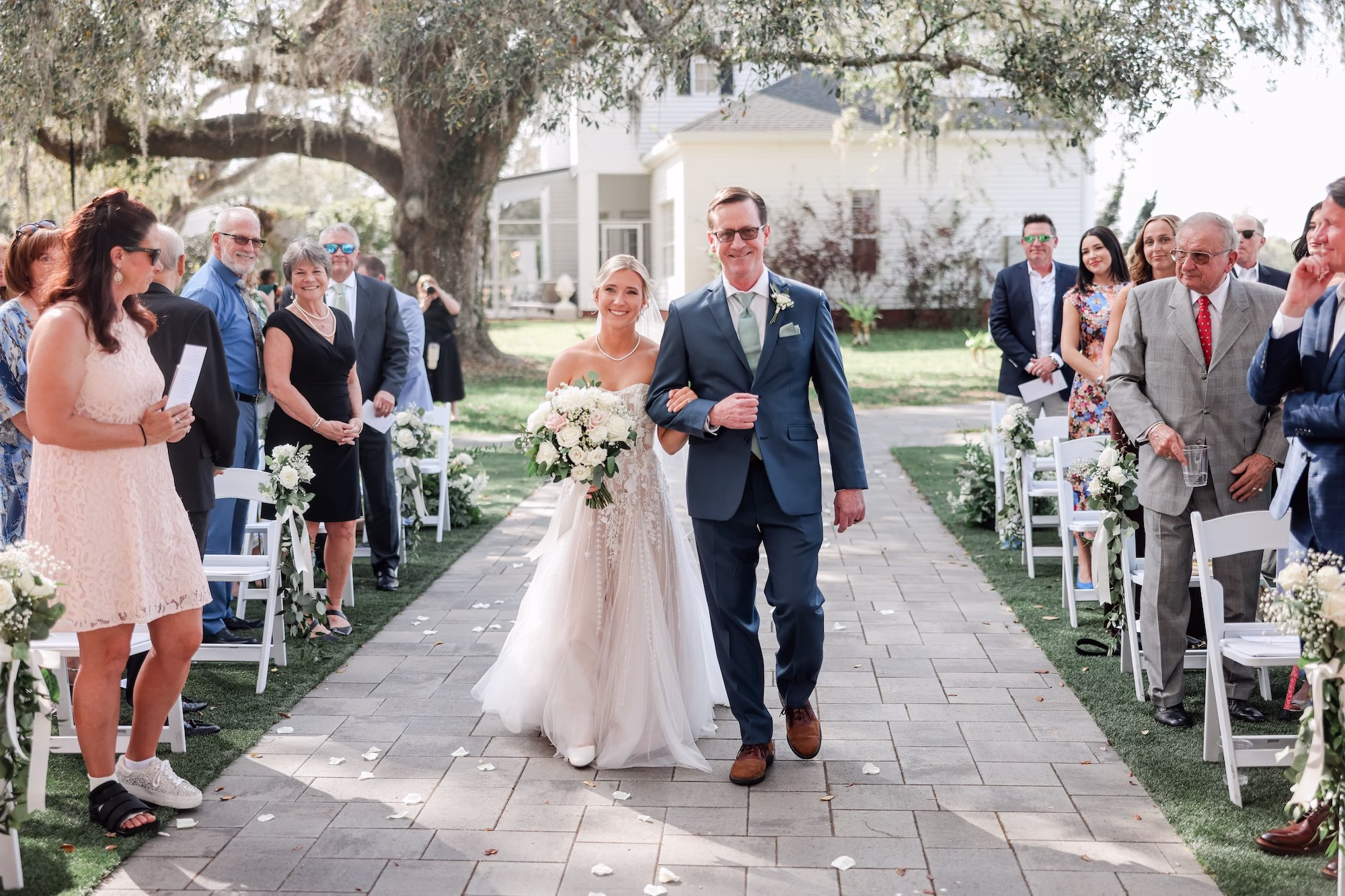 Bride and Father Walking Down Wedding Ceremony Aisle | Classic Natural Bridal Makeup and Low Bun Bridal Hair Inspiration | Tampa Hair and Makeup Adore Bridal | Clearwater Photographer Lifelong Photography Studio