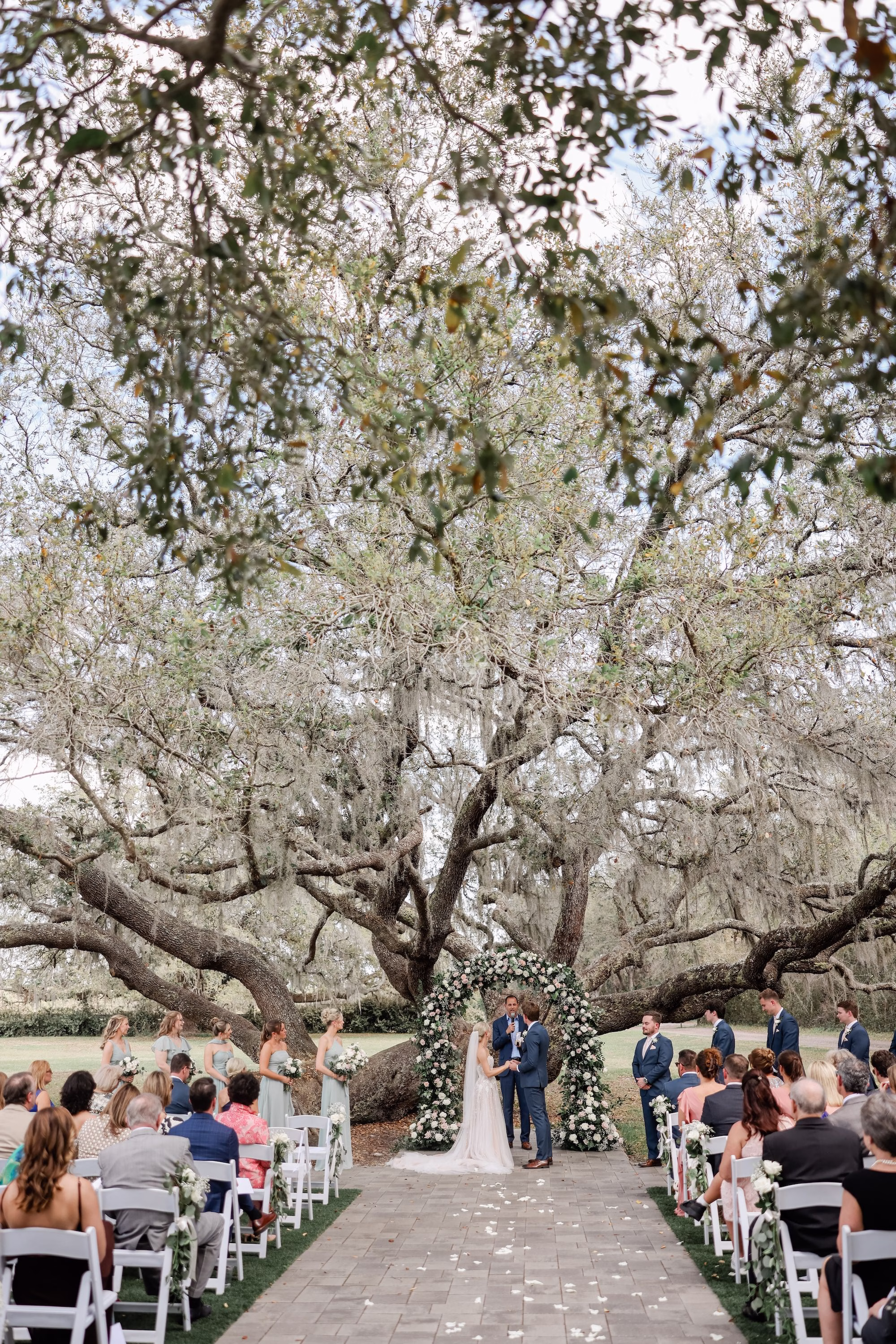Bride and Groom Wedding Ceremony Vow Exchange Wedding Portrait | Spring Garden Outdoor Florida Wedding Inspiration | Whimsical Floral Altar Arch of White, Blush Roses and Greenery Wedding Ceremony Decor Ideas | Clearwater Photographer Lifelong Photography Studio | Tampa Bay Event Venue Legacy Lane Weddings