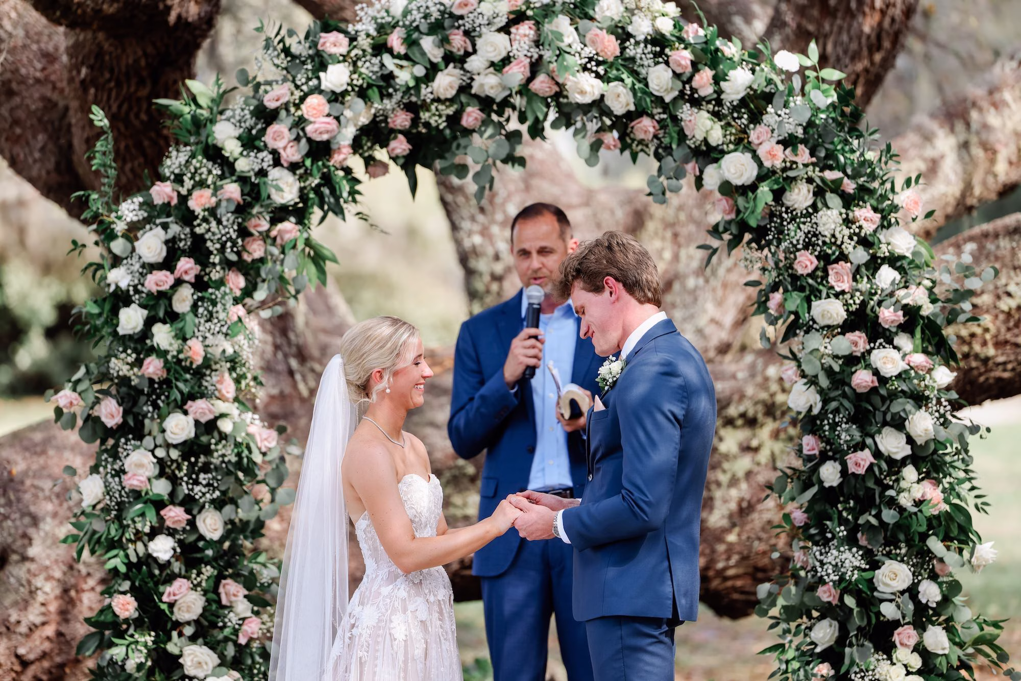 Bride and Groom Wedding Ceremony Vow Exchange Wedding Portrait | Spring Garden Outdoor Florida Wedding Inspiration | Whimsical Floral Altar Arch of White, Blush Roses and Greenery Wedding Ceremony Decor Ideas | Clearwater Photographer Lifelong Photography Studio | Tampa Bay Event Venue Legacy Lane Weddings