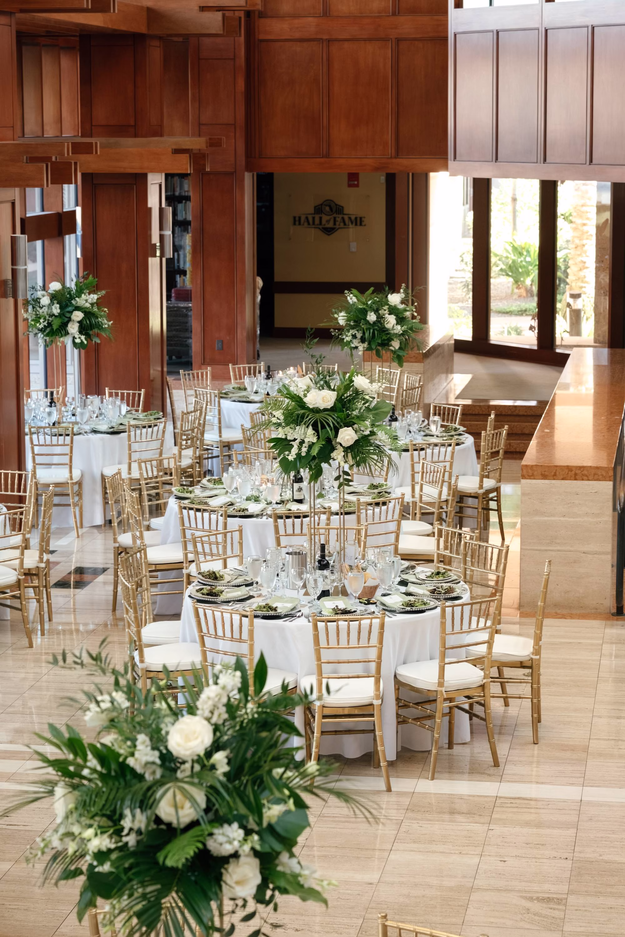 36Tropical Green Florida Wedding Ideas - Tropical, Green Downtown St. Pete Wedding | Poynter Institute Tropical Green and White Luxurious Ballroom Wedding Reception | Modern Gold Chiavari Chairs | Tall Gold Platform Centerpieces with White Florals and Greenery Arrangement Ideas | St Pete Event Planner Coastal Coordinating | Florida Venue Poynter Institute