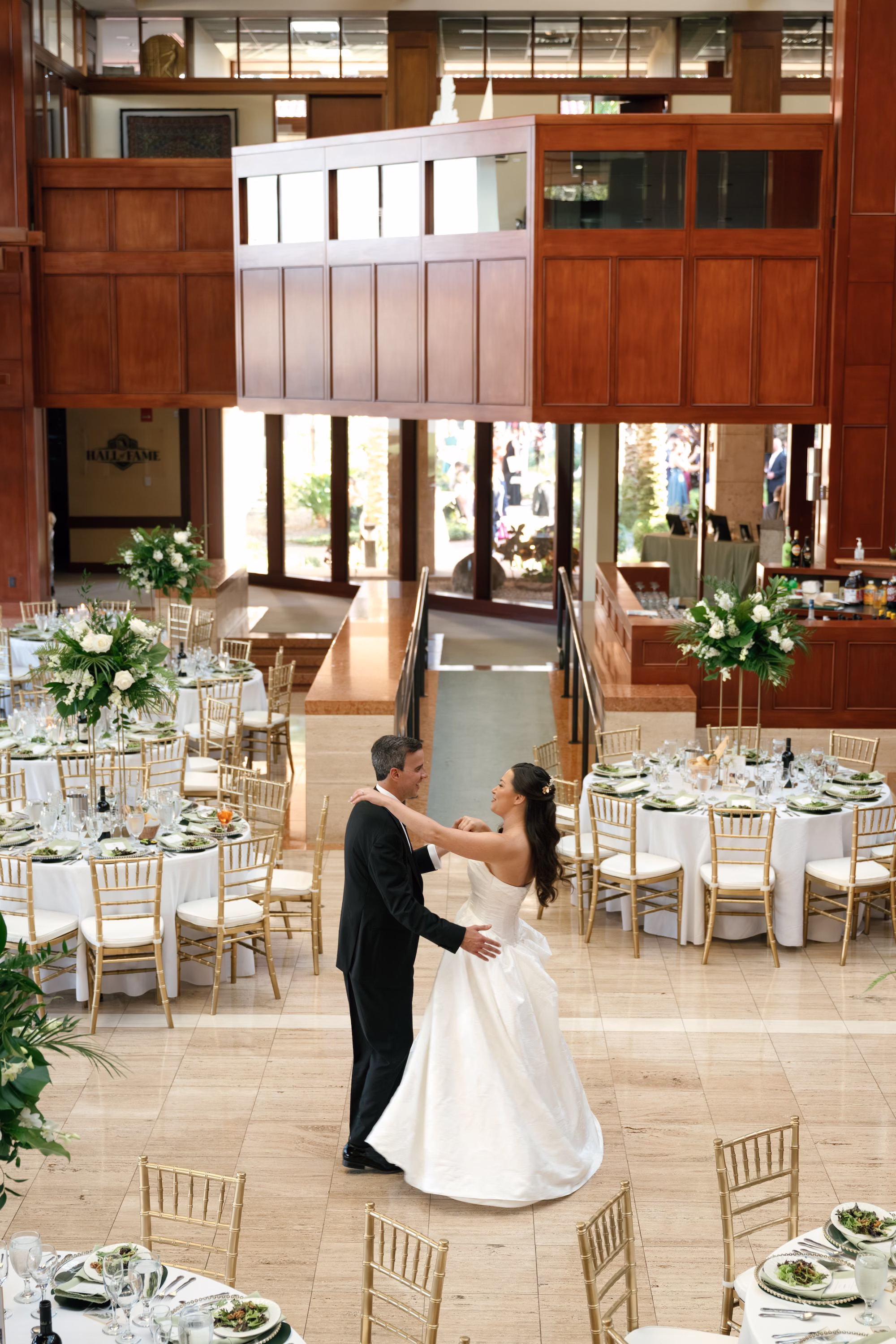 46Tropical Green Florida Wedding Ideas St Pete Venue Poytner Institute - Tropical, Green Downtown St. Pete Wedding | Poynter Institute Bride and Groom First Dance Wedding Portrait | Tropical Green and White Luxurious Ballroom Wedding Reception | Modern Gold Chiavari Chairs | Tall Gold Platform Centerpieces with White Florals and Greenery Arrangement Ideas | St Pete Event Planner Coastal Coordinating | Florida Venue Poynter Institute | Tampa Bay Photographer Dewitt For Love