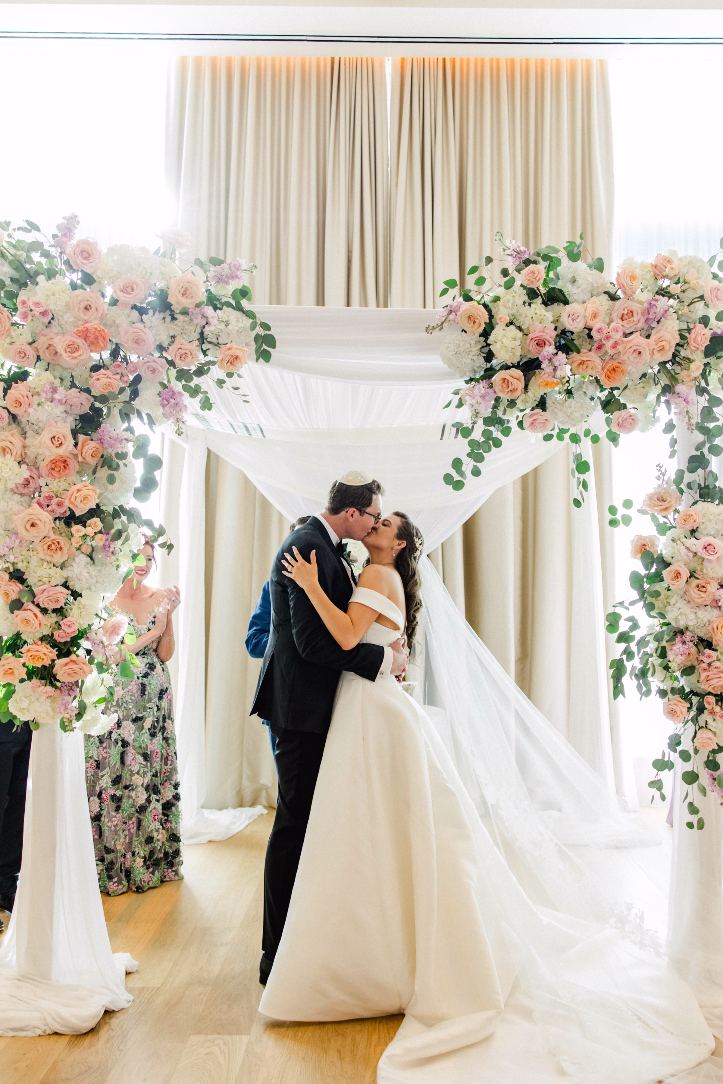 Bride and Groom Wedding Ceremony Just Married Kiss Wedding Portrait | Spring Pastel Roses, Hydrangeas Blush, Peach, Cream, White Wedding Ceremony Floral Arrangement Decor Inspiration | White Draping and Spring Floral Decor on Wedding Chuppah Jewish Wedding Ceremony Decor Ideas | Downtown Event Venue The Edition Hotel Tampa