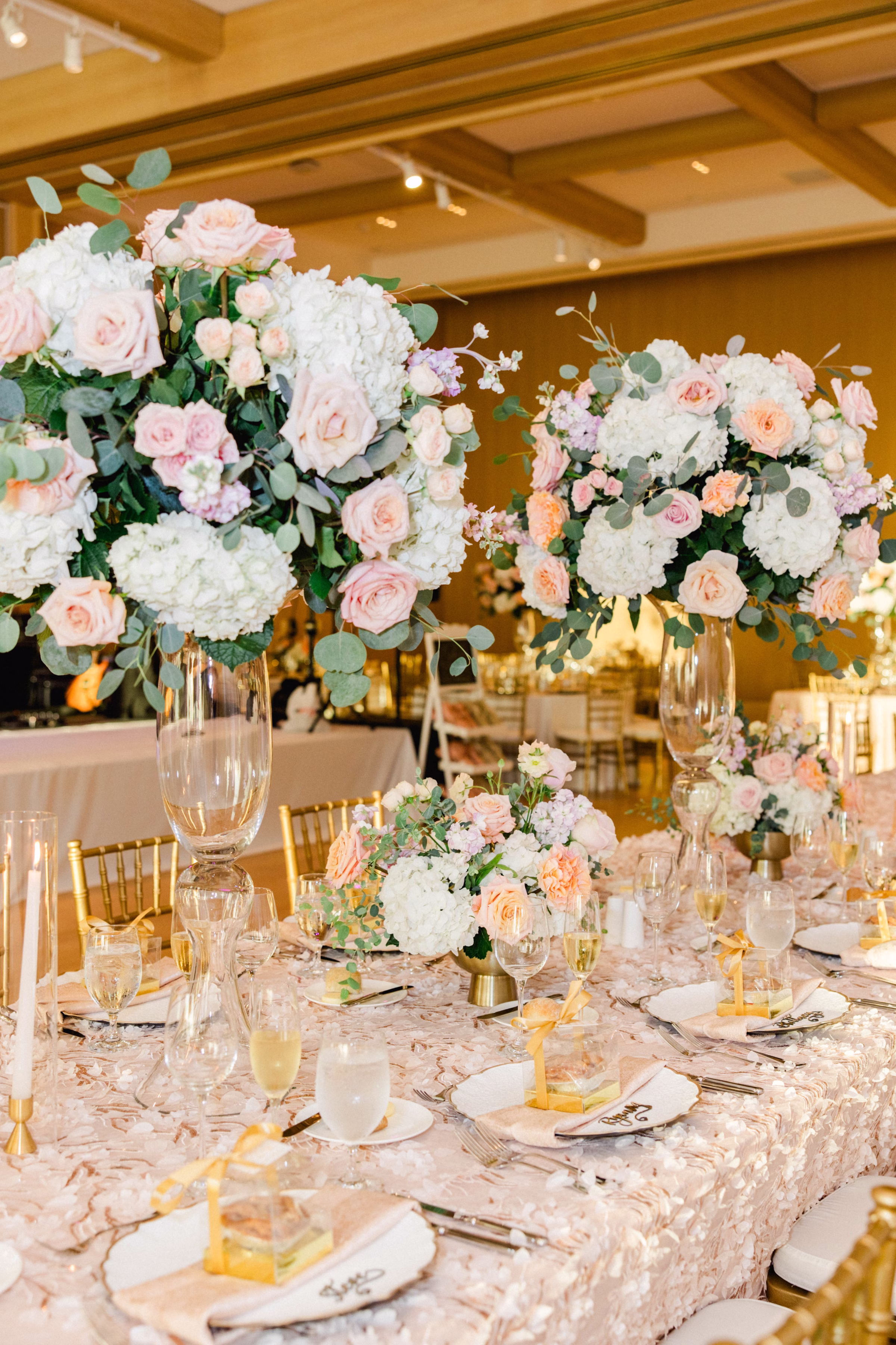 Luxurious Ballroom Wedding Reception | Modern Gold Chiavari Chairs | Tall Glass Spring Pastel Centerpieces with Blush Pink, White Hydrangeas and Roses Flower Arrangement Centerpiece Ideas | Long Feasting Table with Textured Blush Floral Table Linen Decor Inspiration | Downtown Event Venue The Edition Hotel Tampa