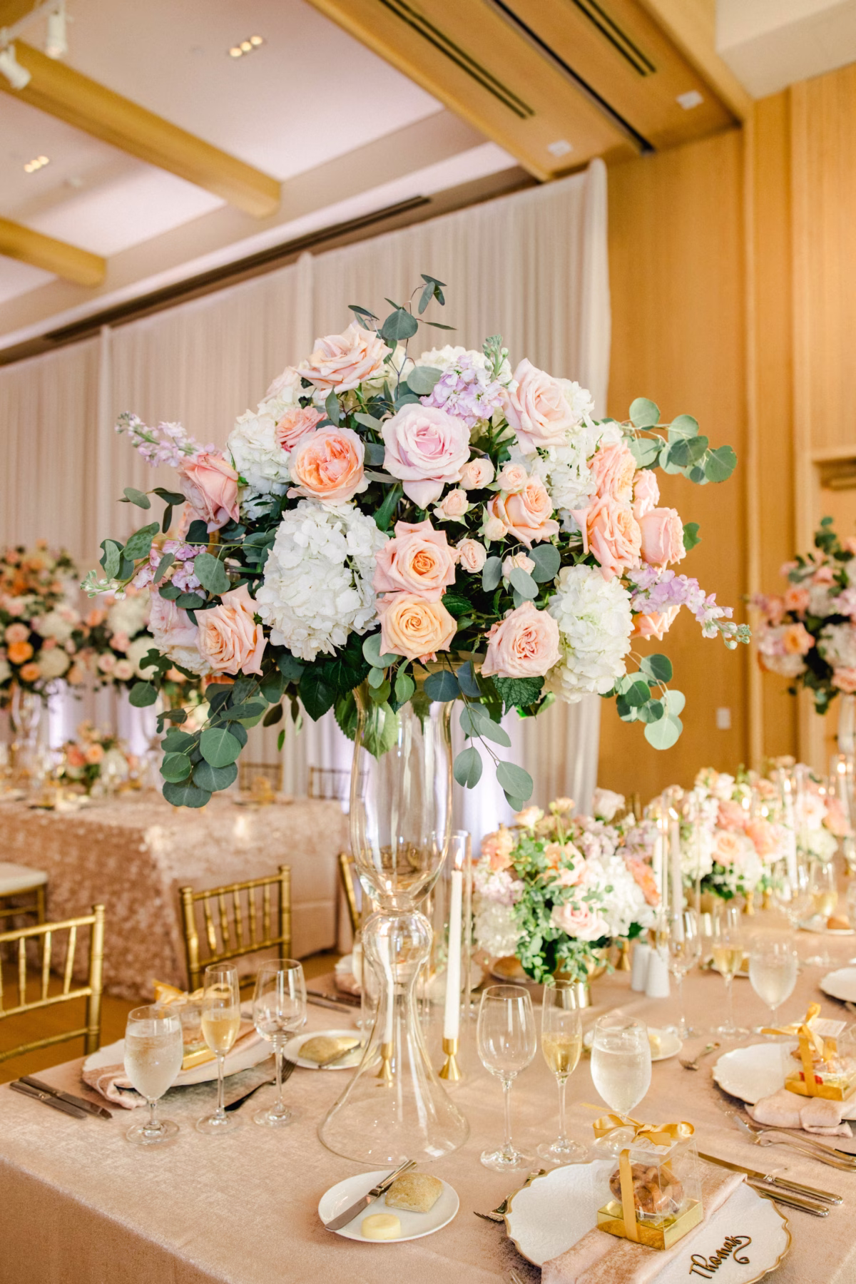 Luxurious Ballroom Wedding Reception | Modern Gold Chiavari Chairs | Tall Glass Spring Pastel Centerpieces with Blush Pink, White Hydrangeas and Roses Flower Arrangement Centerpiece Ideas | Long Feasting Table with Textured Blush Floral Table Linen Decor Inspiration | Downtown Event Venue The Edition Hotel Tampa