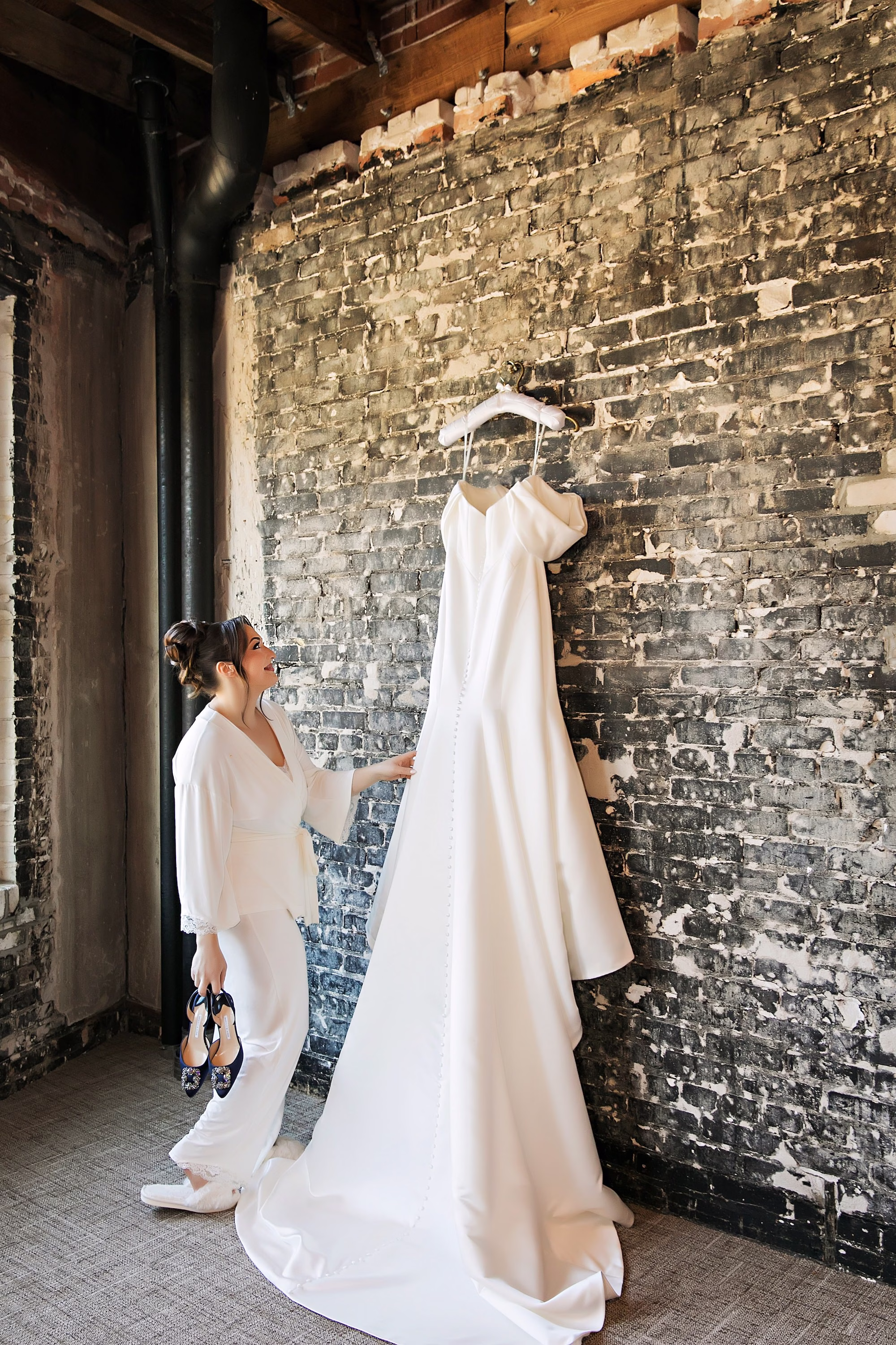 Bride Getting Ready Wedding Portrait | Off the Shoulder Fit and Flare White Closet Bridal Company Hanging on Brick Wall Inspiration | Tampa Bay Photographer Limelight Photography