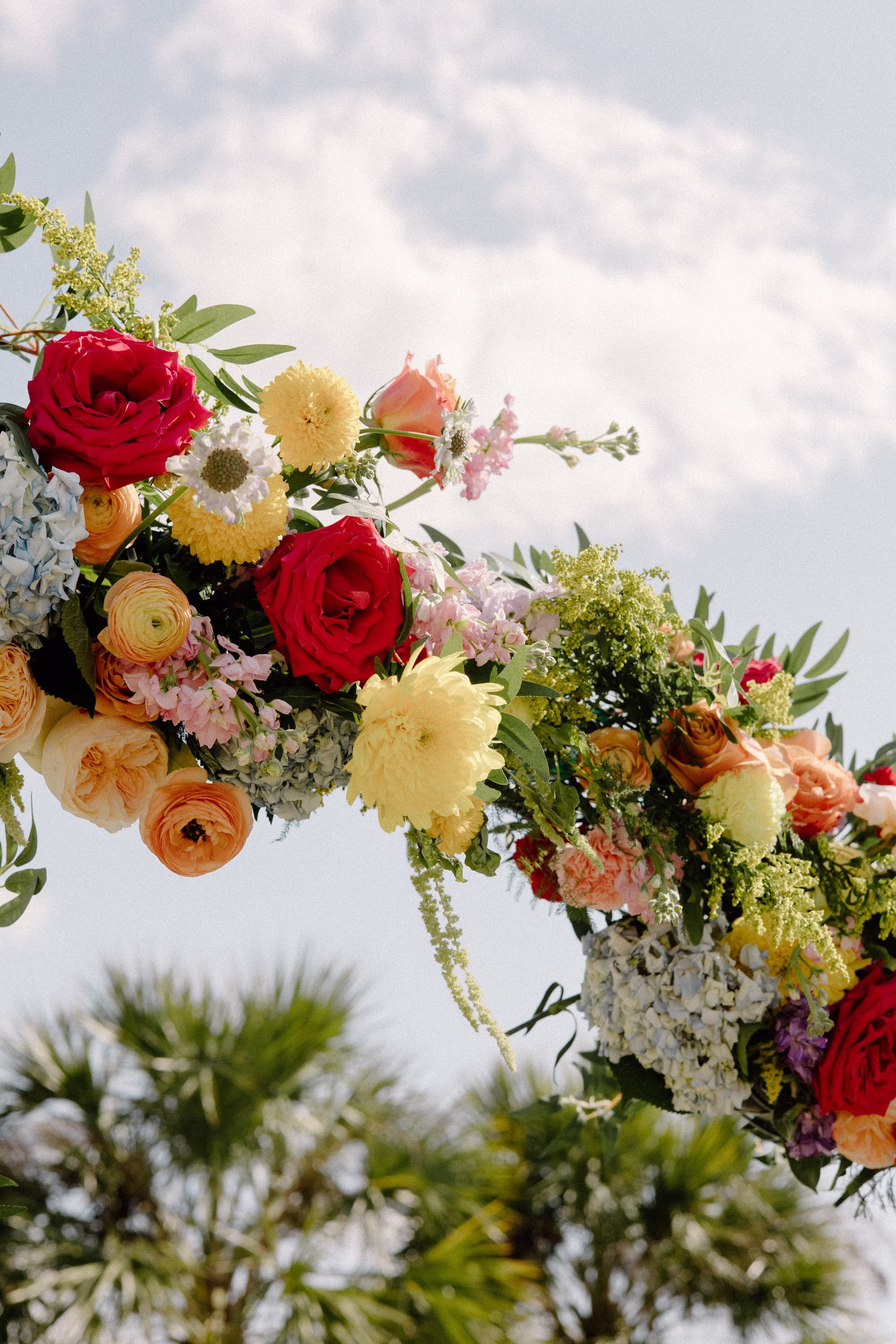 16Whimsical Pastel Spring Orange Yellow and Purple Wedding Inspiration - Whimsical, Colorful Waterfront Wedding | Tampa River Center Vibrant Floral Wedding Ceremony Altar Arch of Bright Red Roses, Pastel Orange Ranunculus, Fluffy Yellow Chrysanthemums Decor Inspiration