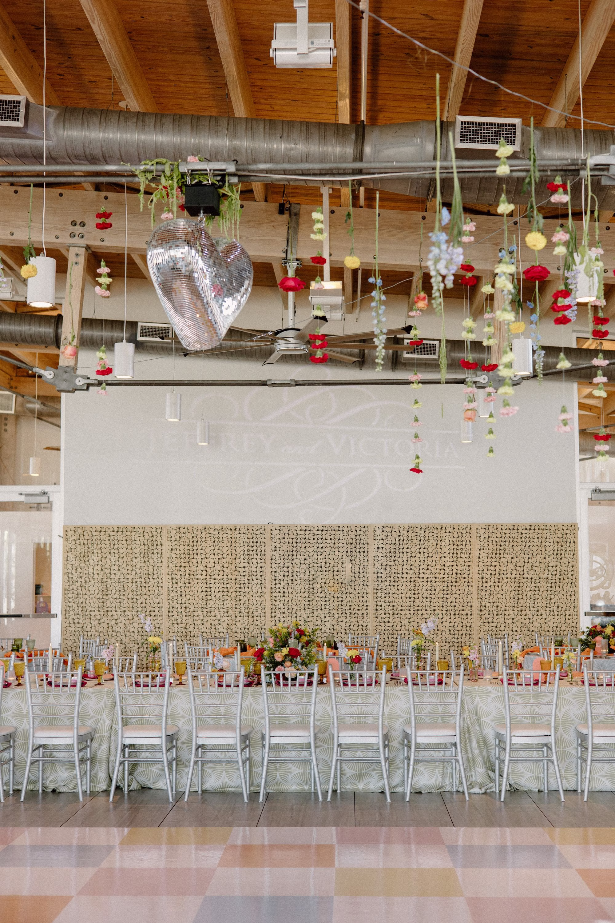 34Whimsical Pastel Spring Orange Yellow and Purple Wedding Inspiration Venue Tampa River Center - Whimsical, Colorful Waterfront Wedding | Tampa River Center Whimsical Spring Colorful Wedding Reception Decor Inspiration | Heart Wedding Reception Dance Floor Disco Ball Decor Ideas | Single Stem Spring Red, Pink, Yellow Florals Hanging Ceiling Decor Inspiration | Multi Color Checkered Dance Floor Ideas | Tampa Bay Planner Wilder Mind Events | Tampa Bay DJ Tampa Bay DJ Co