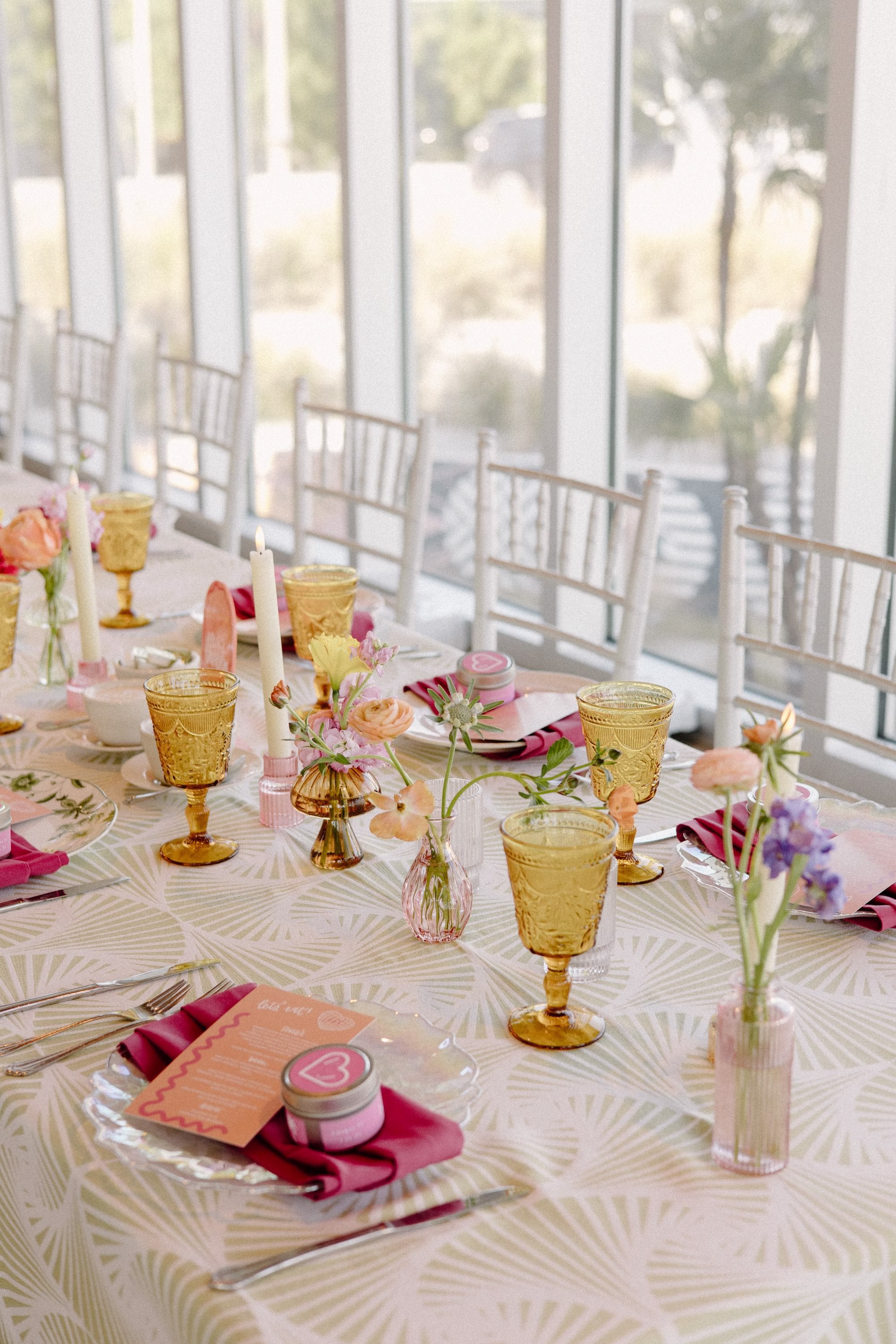 36Whimsical Pastel Spring Orange Yellow and Purple Wedding Inspiration - Whimsical, Colorful Waterfront Wedding | Tampa River Center White Chiavari Chairs with Textured Linens Decor Inspiration | Colored Depression Glassware with Bright Pink Napkins Tablescape Reception Decor Ideas | Single Pastel Floral Stems in Bud Vases Centerpiece Inspiration | Planner Wilder Mind Events