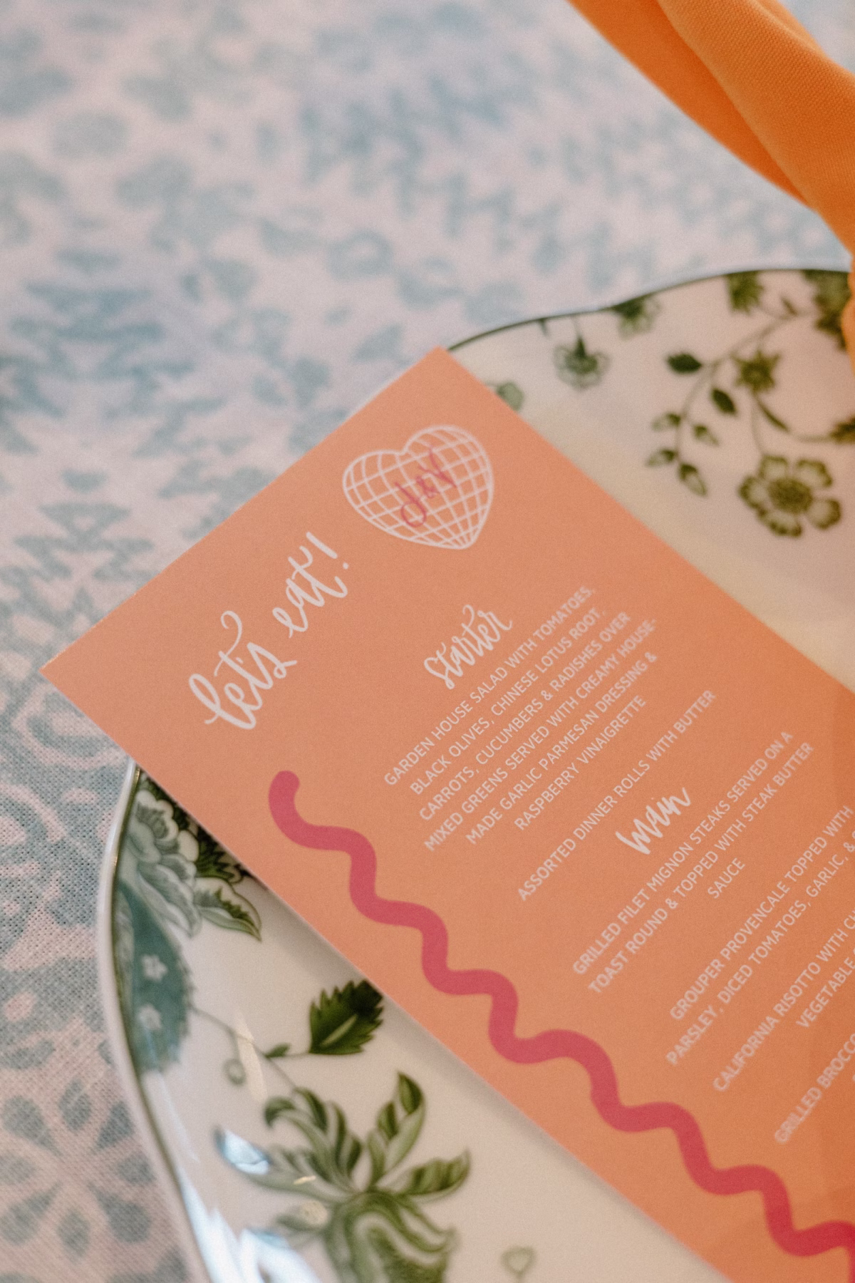 37Whimsical Pastel Spring Orange Yellow and Purple Wedding Inspiration - Whimsical, Colorful Waterfront Wedding | Tampa River Center Colorful Whimsical Orange and Red Wedding Reception Menu Card on Green Floral China Tablescape Decor Inspiration | Planner Wilder Mind Events