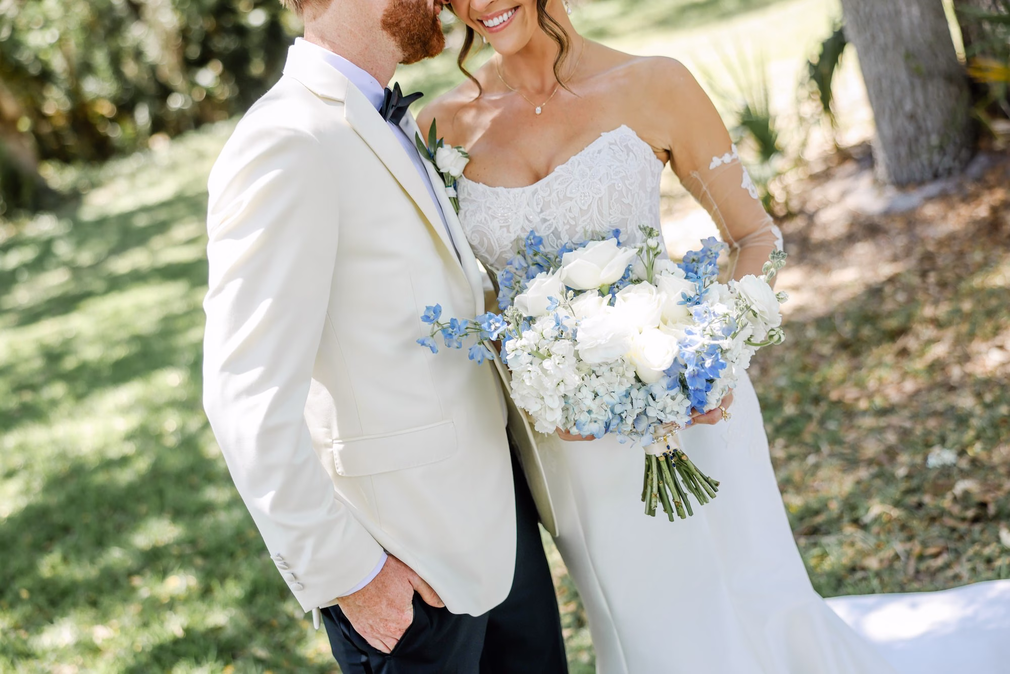 Bride and Groom Outdoor Spring Wedding Portrait | White Roses with White and Blue Hydrangeas Wedding Bridal Bouquet Inspiration | Elegant Strapless The Dessy Group White Wedding Gown with Lace Bodice and Sleeves Ideas | Clearwater Photographer Lifelong Photography Studio | Tampa Boutique Truly Forever Bridal | Content Creator Behind The Vows