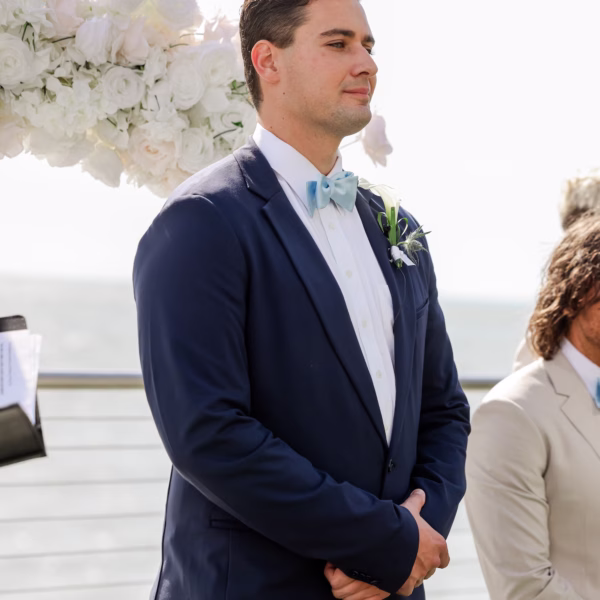16Elegant Light Blue Coastal Florida Wedding Ideas - Elegant Blue Modern Coastal Wedding | Opal Sands Clearwater Beach Groom's Reaction to Bride Walking Down Wedding Ceremony Aisle in Navy Suit and Light Blue Bow Tie