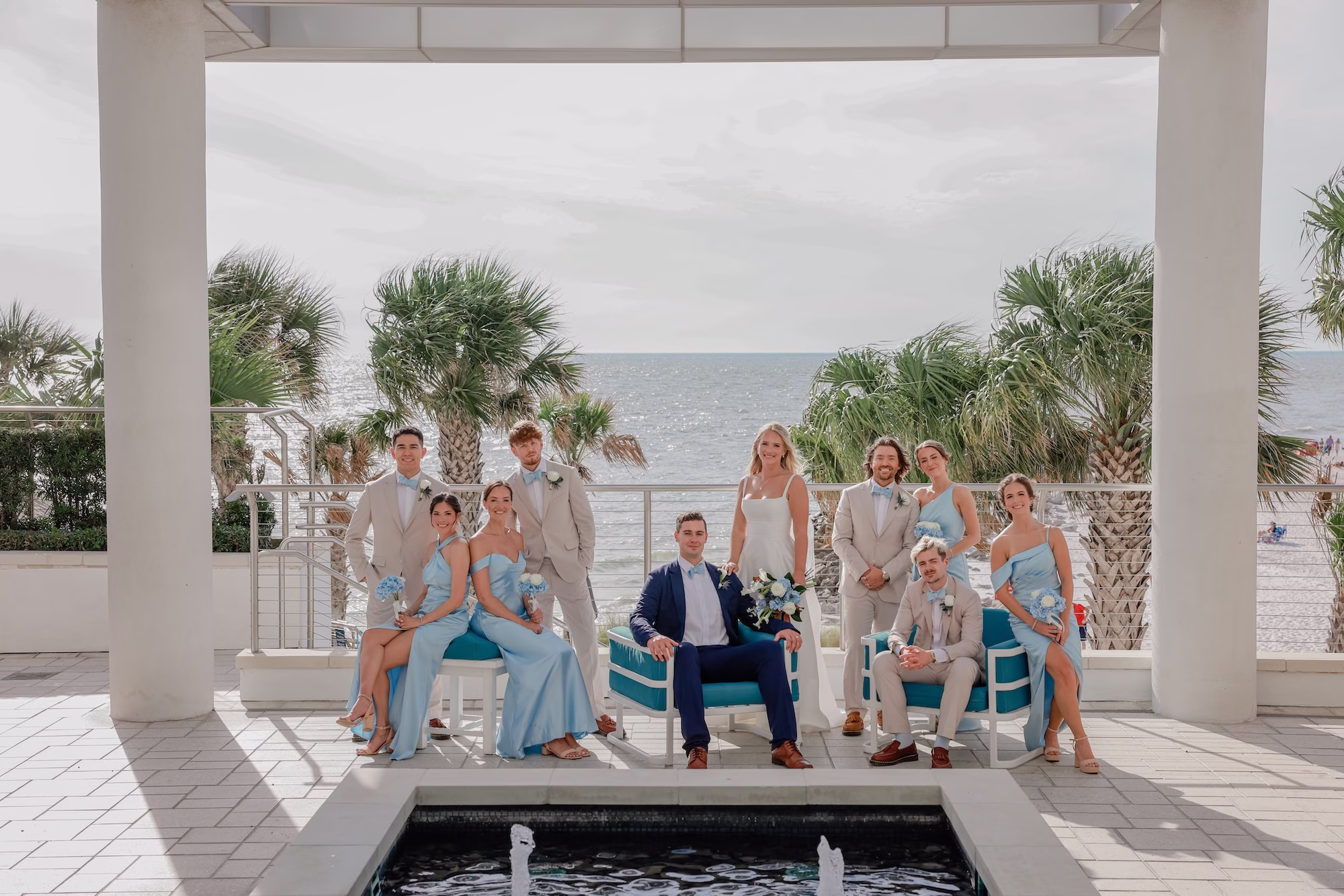 26Elegant Light Blue Coastal Florida Wedding Ideas - Elegant Blue Modern Coastal Wedding | Opal Sands Clearwater Beach Wedding Party Portrait Under White Resort Pergola with Light Blue Bridesmaid Dresses and Tan Suits | Clearwater Beach Venue Opal Sands Resort | Photography Lifelong Photography Studio