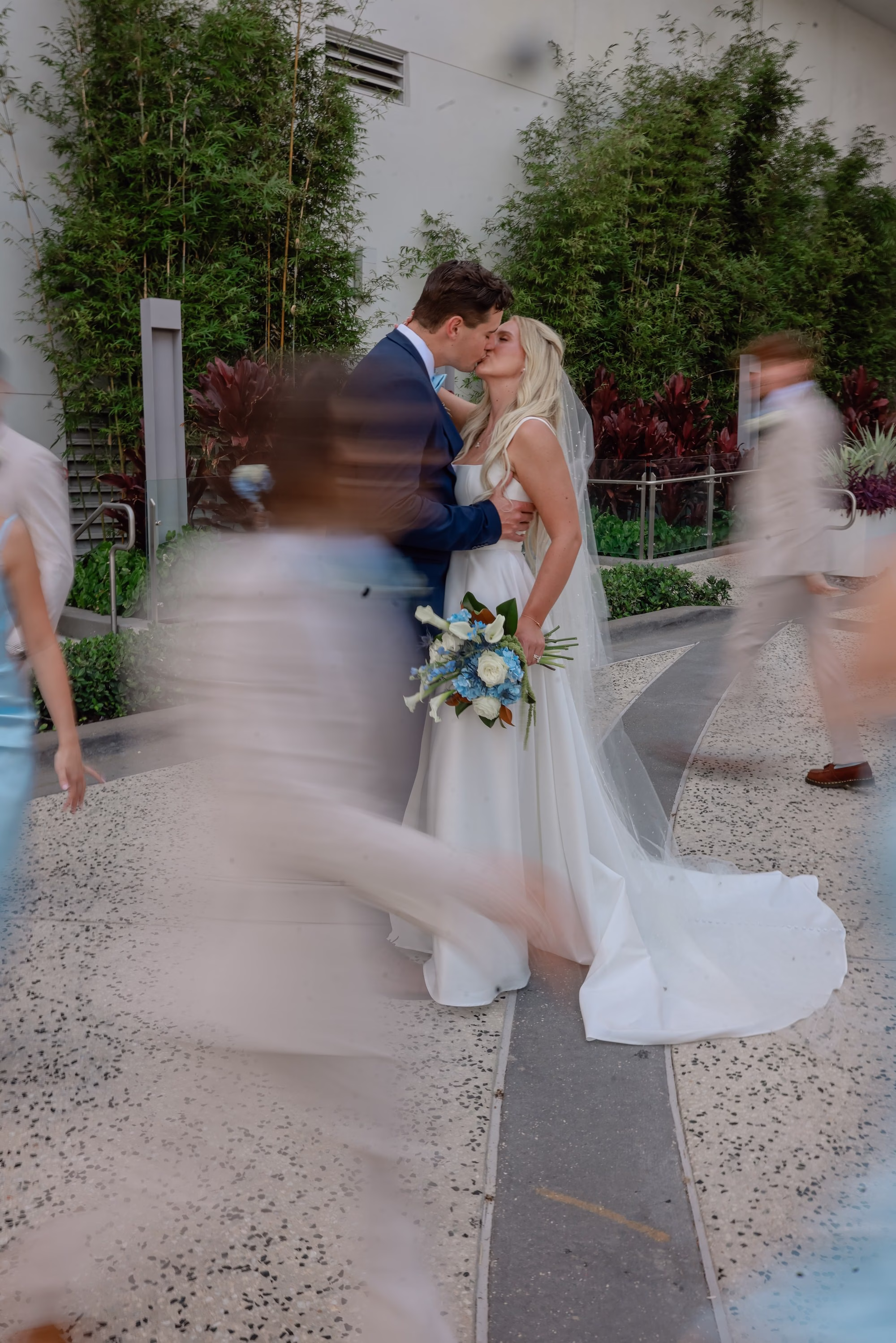 27Elegant Light Blue Coastal Florida Wedding Ideas - Elegant Blue Modern Coastal Wedding | Opal Sands Clearwater Beach Motion Blur Wedding Party Walking Portrait with Bride in Ivory Satin Ballgown and Blue Hydrangea Bouquet | Tampa Bay Photography Lifelong Photography Studio