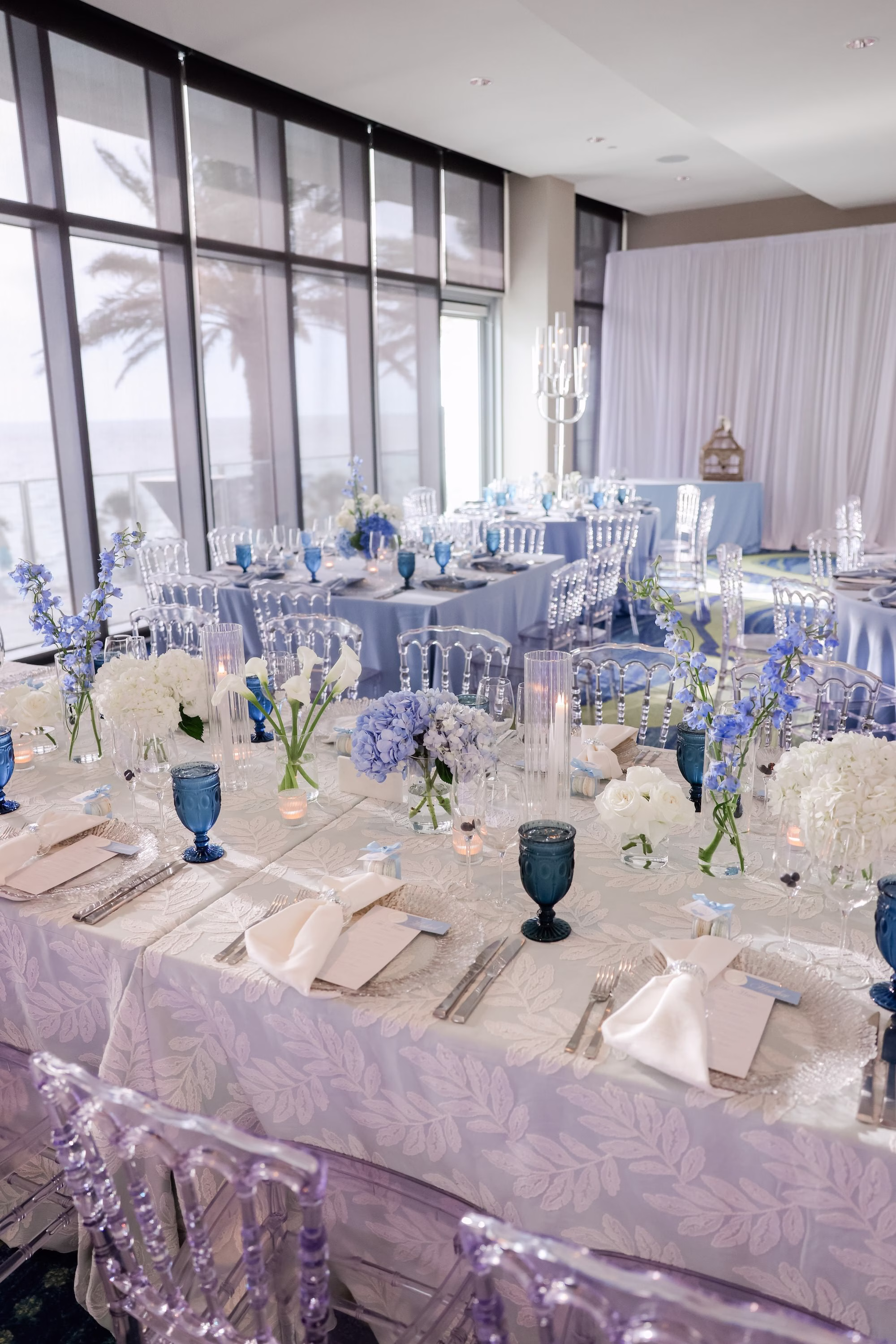 33Elegant Light Blue Coastal Florida Wedding Ideas - Elegant Blue Modern Coastal Wedding | Opal Sands Clearwater Beach Light Blue and White Wedding Reception Tablescape with Navy Blue Goblets, Clear Chiavari Chairs and Hydrangea Centerpieces Overlooking Palm Trees Ideas | Clearwater Beach Venue Opal Sands Resort | Gabro Event Rentals