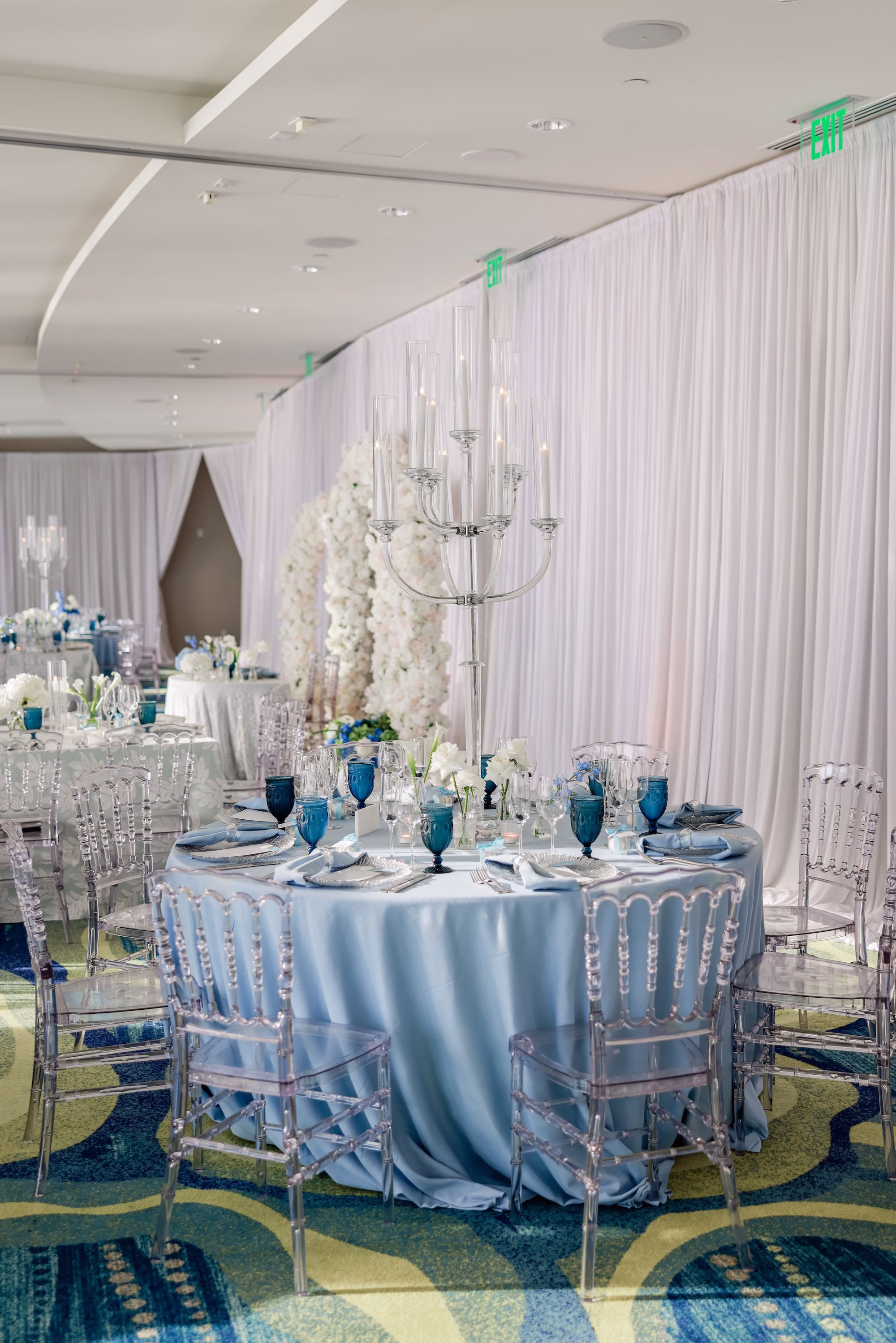 43Elegant Light Blue Coastal Florida Wedding Ideas - Elegant Blue Modern Coastal Wedding | Opal Sands Clearwater Beach Round Wedding Reception Table with Light Blue Satin Linen, Clear Chiavari Chairs and White Draping with Crystal Candelabra Ideas | Clearwater Beach Venue Opal Sands Resort | Gabro Event Rentals