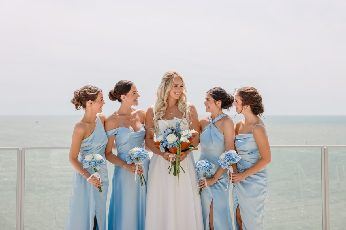 8Elegant Light Blue Coastal Florida Wedding Ideas - Elegant Blue Modern Coastal Wedding | Opal Sands Clearwater Beach Bride and Bridesmaids Wedding Party Portrait in Mismatched Light Blue Satin Bridesmaid Dresses with Blue Hydrangea Bouquets Overlooking the Gulf | Tampa Bay Photography Lifelong Photography Studio