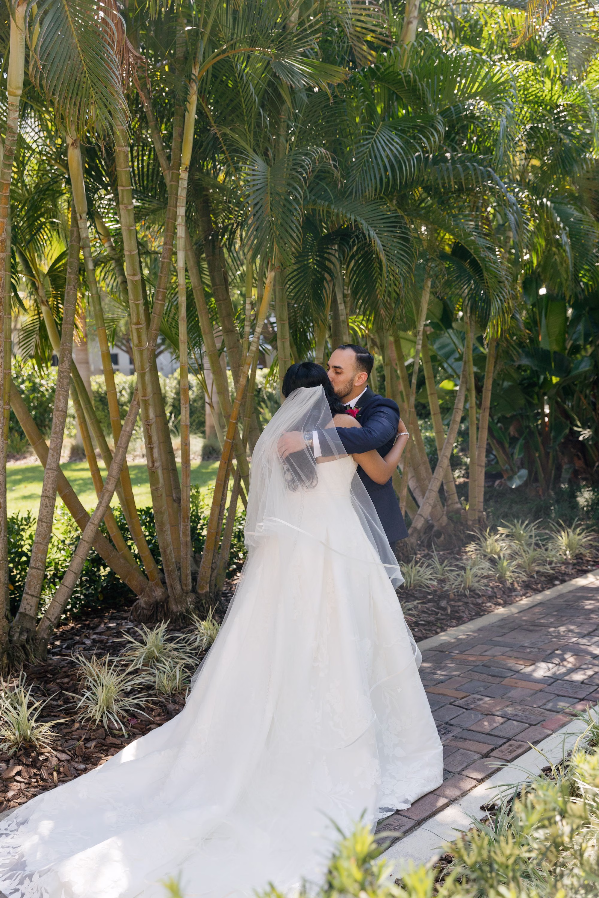 Bride and Groom First Look Wedding Portrait Under Palm Trees in White Strapless Ballgown and Cathedral Veil