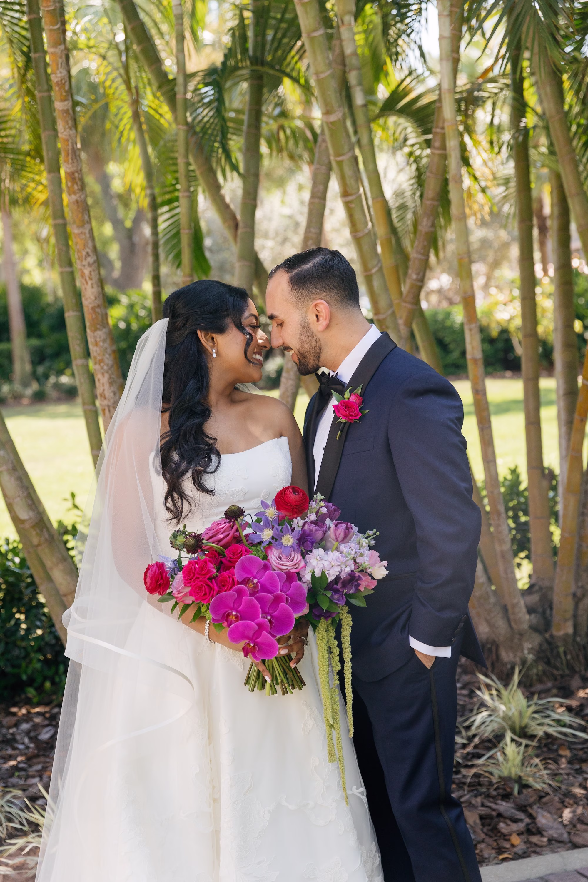 Bride in White Strapless Ballgown and Groom in Navy Tuxedo with Fuchsia Boutonniere Wedding Portrait with Vibrant Pink and Purple Orchid Bouquet | St. Pete Florist Bruce Wayne Florals