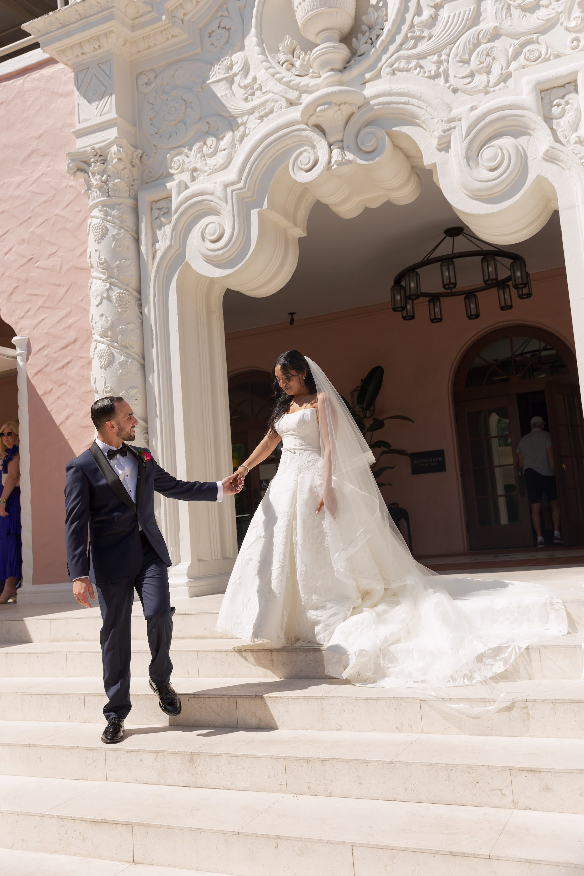 Bride and Groom Wedding Portrait on Steps of Ornate White Mediterranean Revival Entrance | St. Pete Wedding Venue The Vinoy