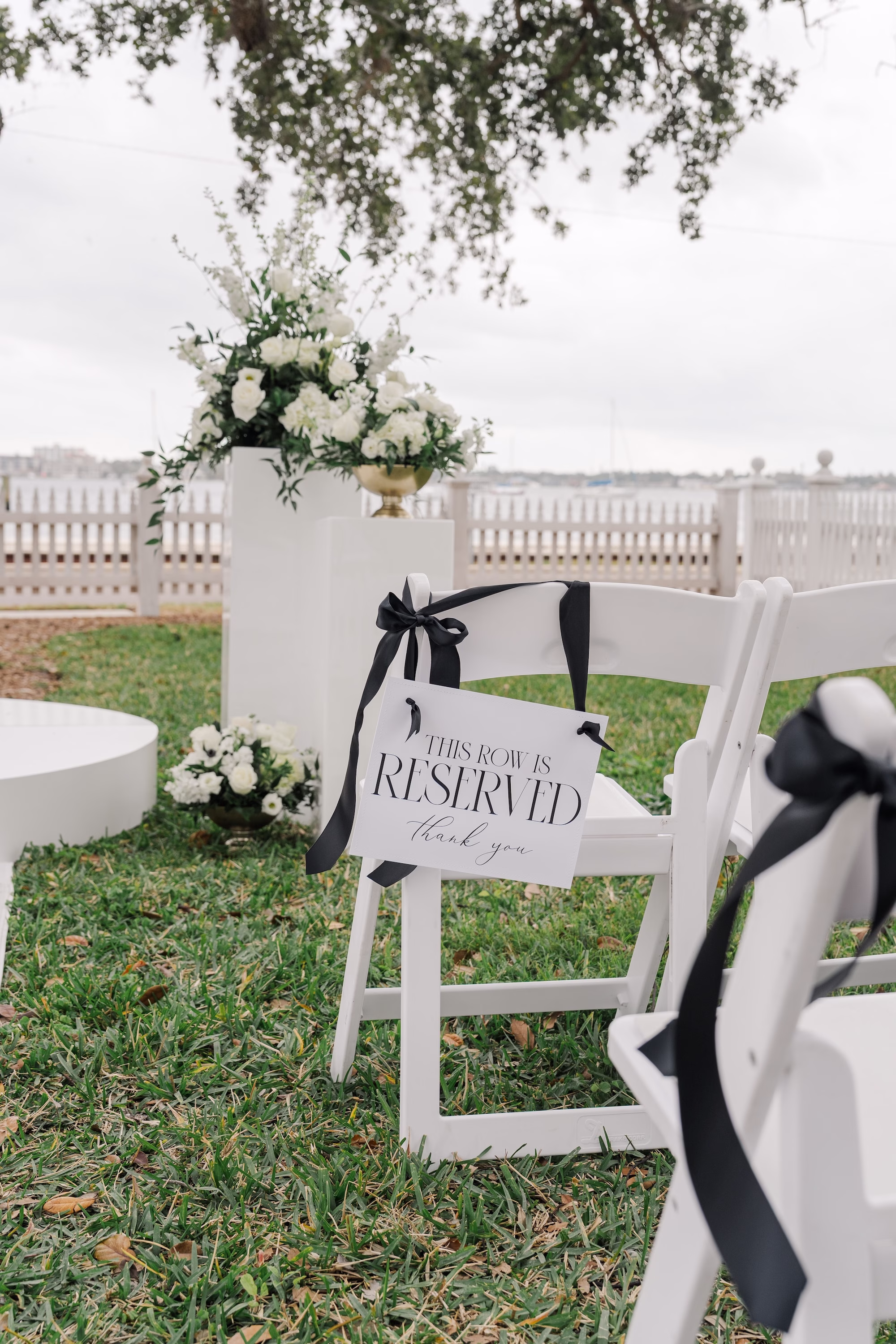 This Row Is Reserved Black and White Wedding Ceremony Sign on White Folding Chair with Black Ribbon Ideas | Palmetto Rentals Kate Ryan Event Rentals