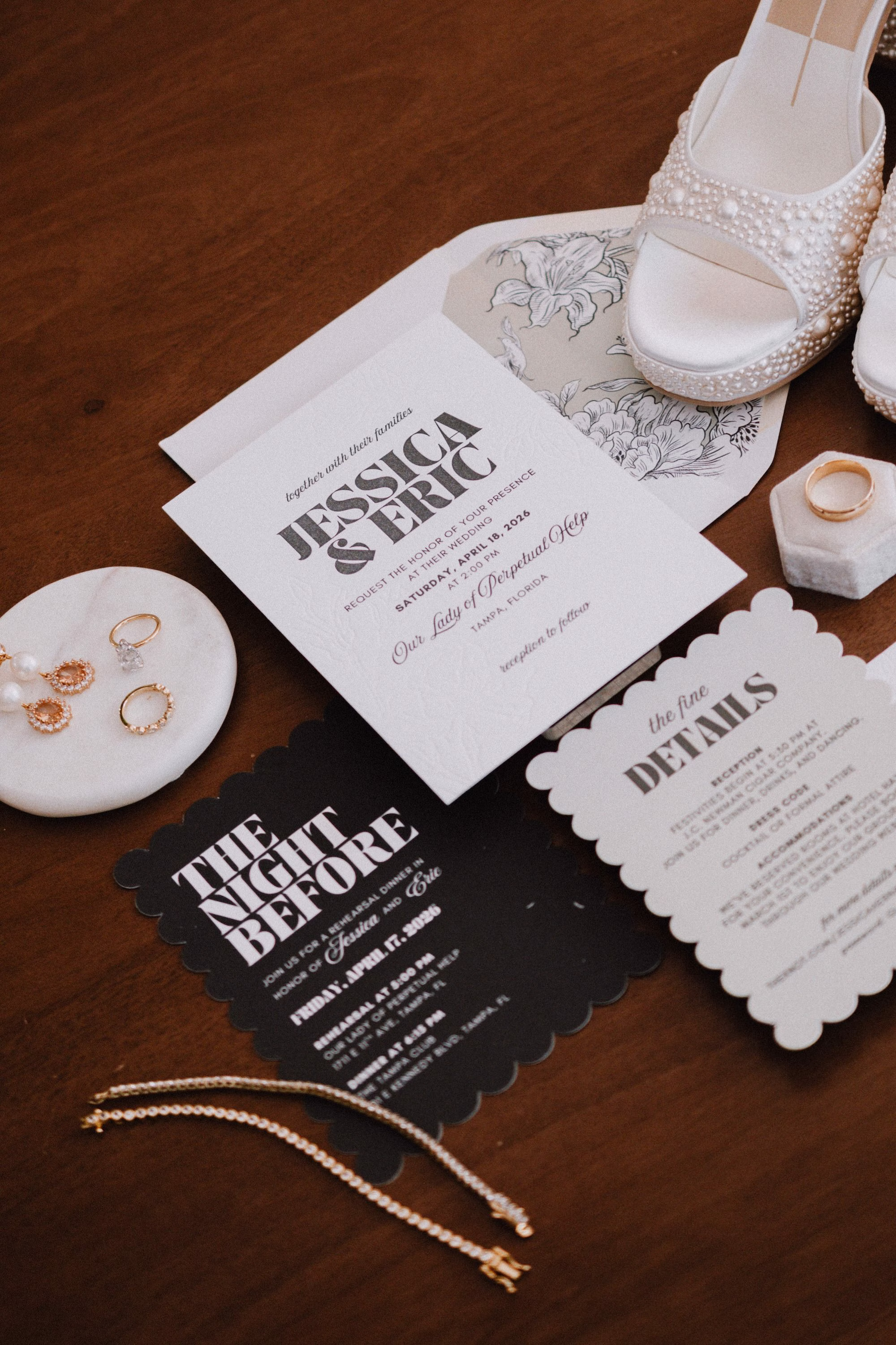 1Classic Modern Black and White Wedding Ideas - Modern Black and Ivory Ybor City Wedding | J.C. Newman Cigar Co. Modern Black and White Wedding Invitation Suite Flat Lay with Scalloped Night Before Card, Pearl Dolce Vita Wedding Shoes and Gold Bridal Jewelry Ideas