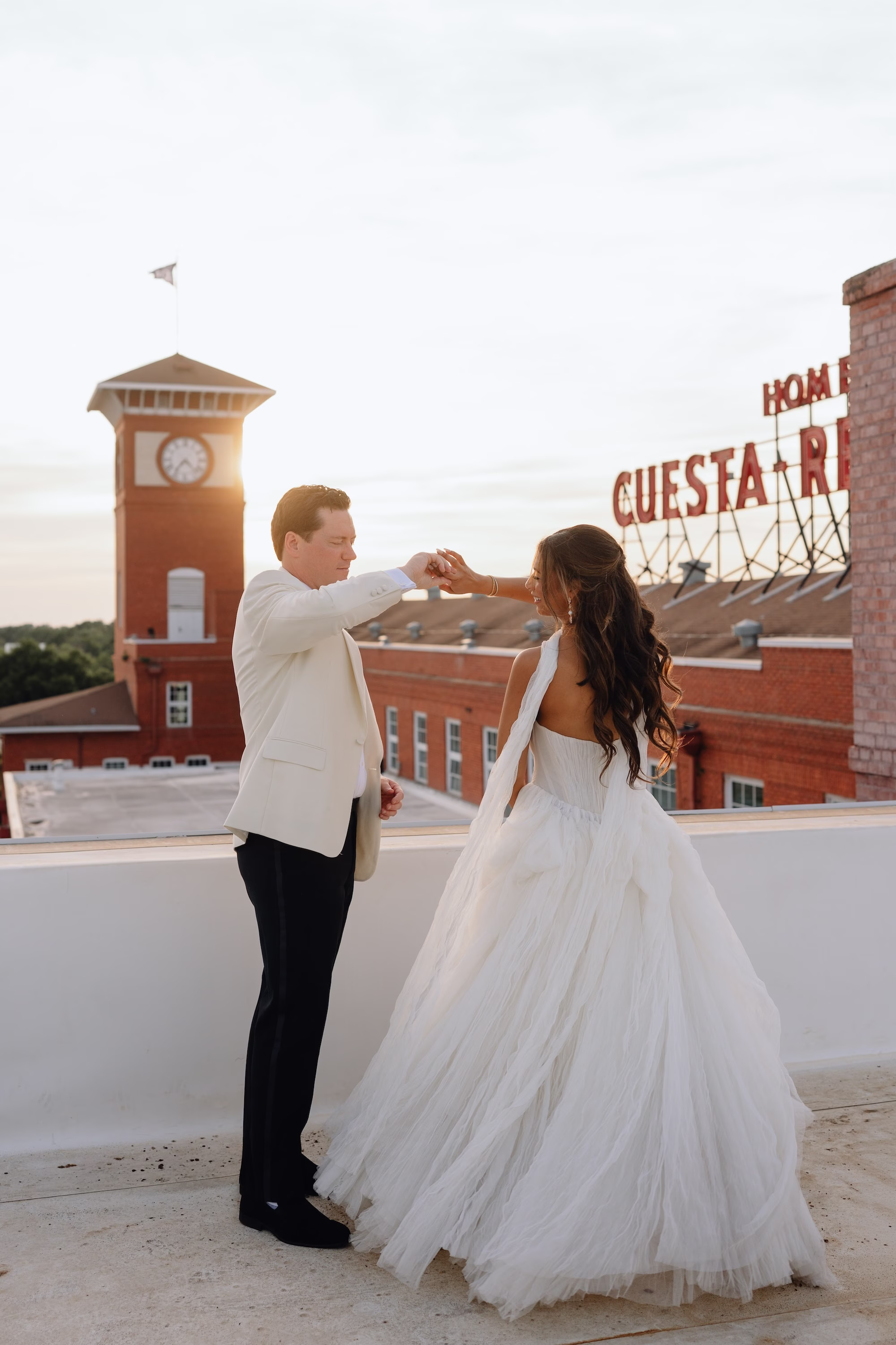 20Classic Modern Black and White Wedding Ideas Tampa Venue JC Newman Cigar Co - Modern Black and Ivory Ybor City Wedding | J.C. Newman Cigar Co. Bride and Groom Rooftop Dance Wedding Portrait at Sunset with Historic Cigar Factory Clock Tower and Cuesta-Rey Sign | Tampa Event Venue J.C. Newman Cigar Co.