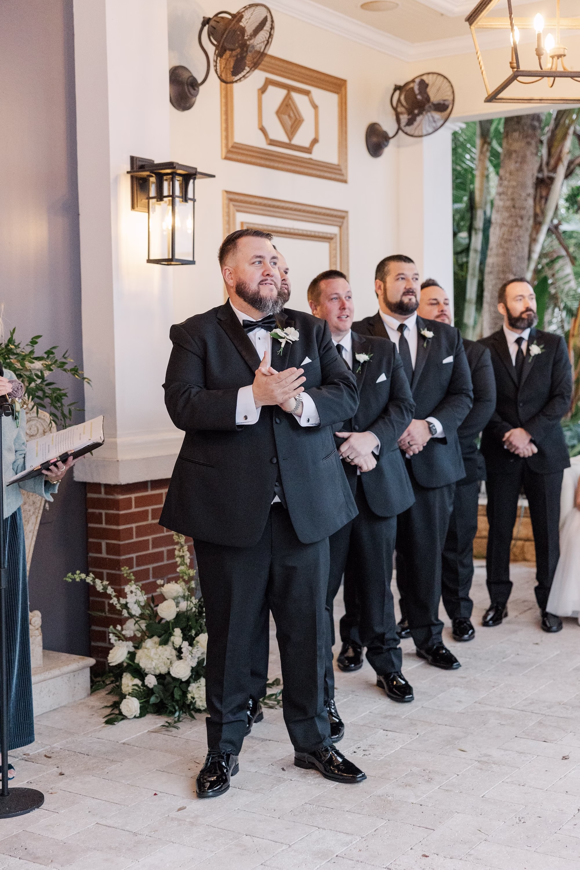 Groom's Reaction to Bride Walking Down Wedding Ceremony Aisle with Groomsmen in Black Tuxedos
