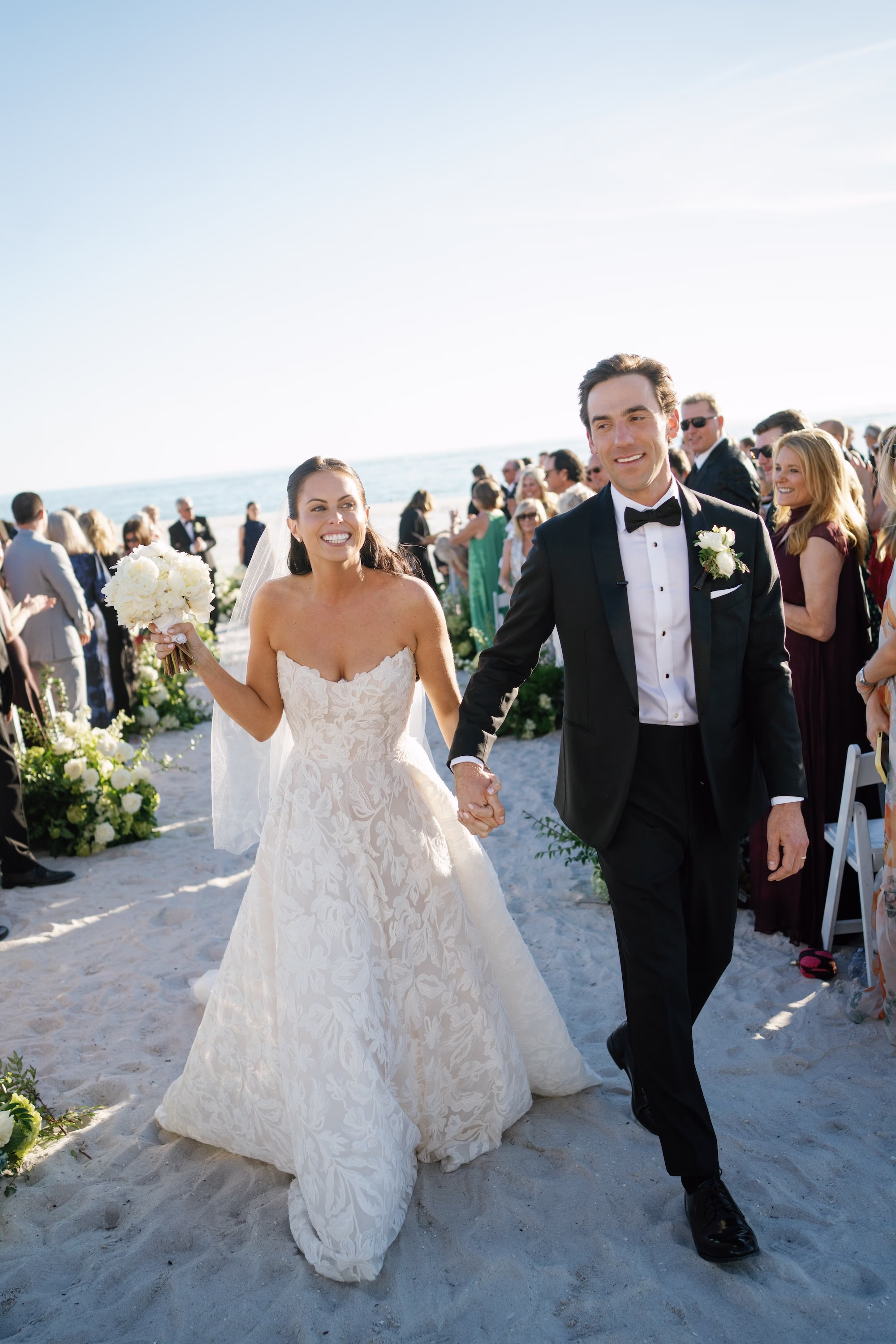 21Coastal Nancy Meyers Inspired Florida Beach Wedding - Coastal Blue, White, and Green Sarasota Wedding | The Resort at Longboat Key Club Bride and Groom Beach Wedding Ceremony Recessional Walking Up Sand Aisle with Cheering Guests