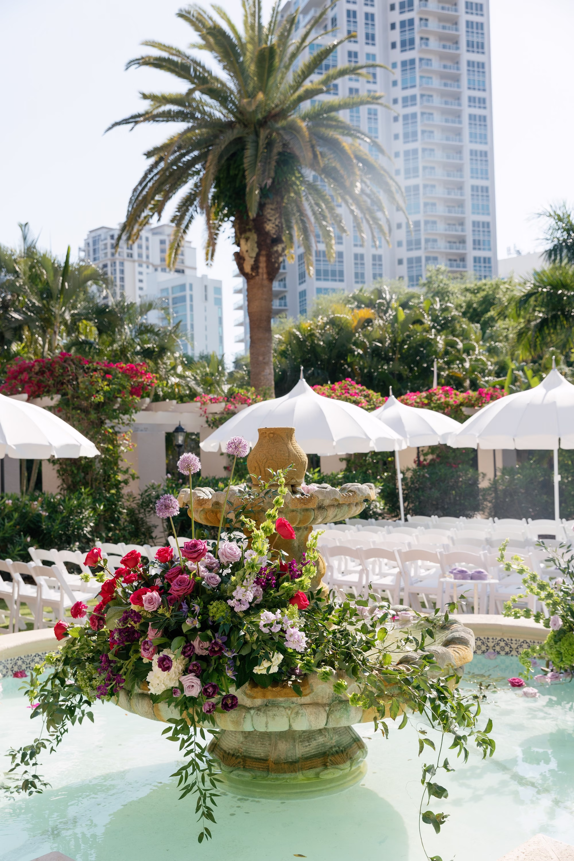 Vibrant Pink and Purple Fountain Floral Arrangement with White Umbrellas Outdoor Wedding Ceremony Decor Ideas | Tea Garden Wedding Ceremony at St. Pete Venue The Vinoy | Florist Bruce Wayne Florals
