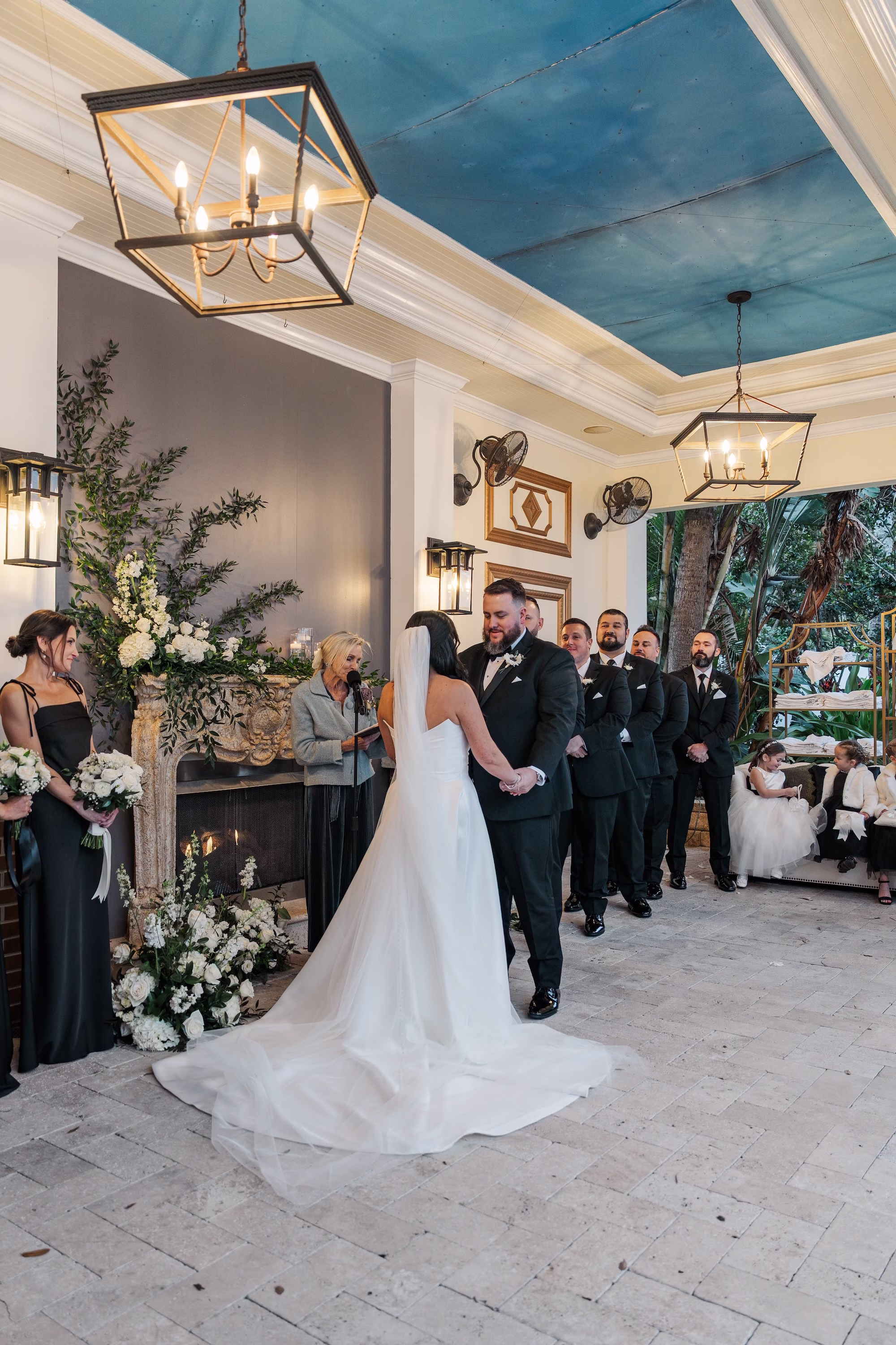 Covered Porch Wedding Ceremony with Greenery Fireplace Installation and Lantern Chandeliers | Wedding Ceremony at Palmetto Venue Palmetto Riverside Bed and Breakfast | Officiant Laurie Chandler Celebrant