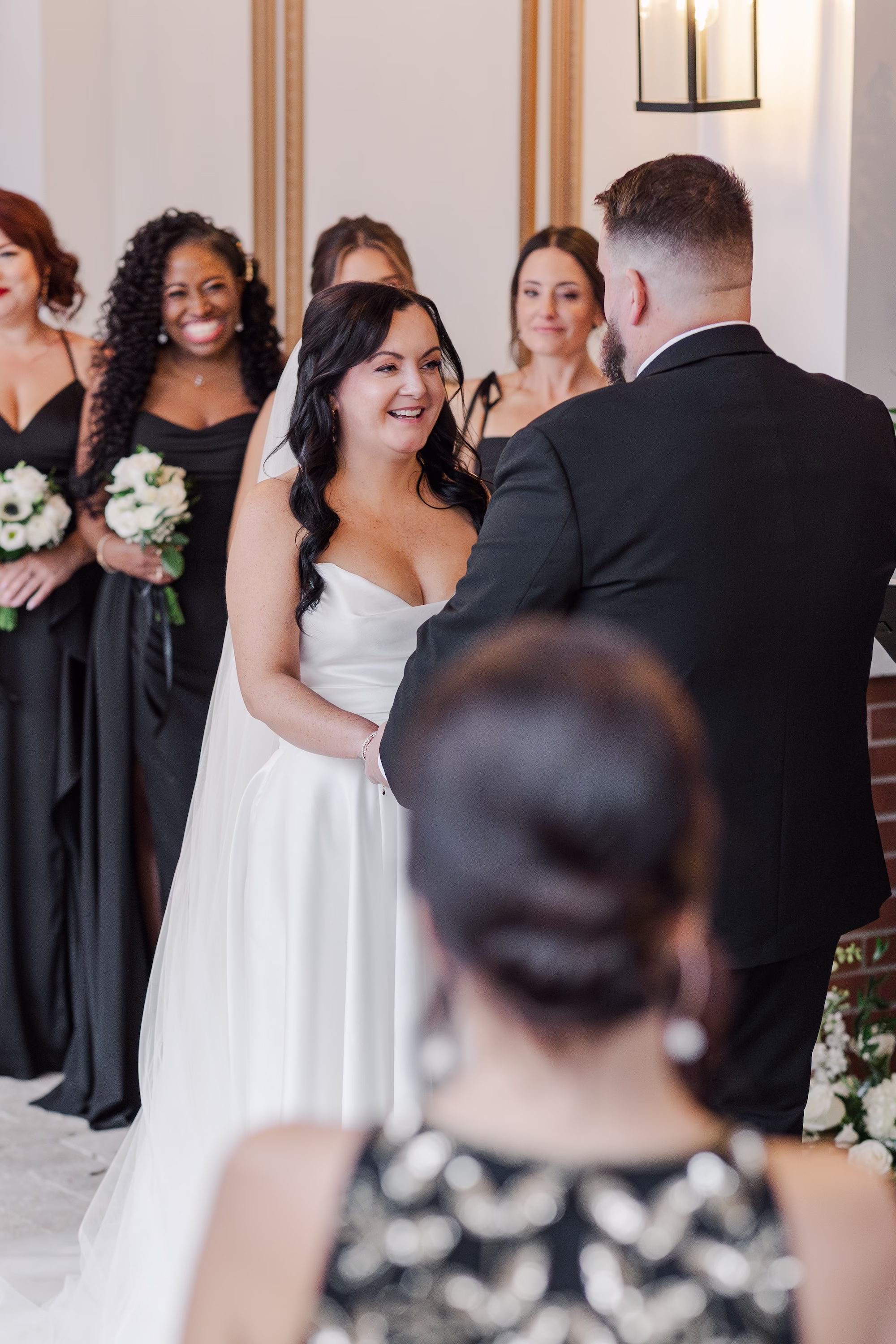 Bride Laughing with Groom Wedding Ceremony Portrait with Bridesmaids in Black Dresses