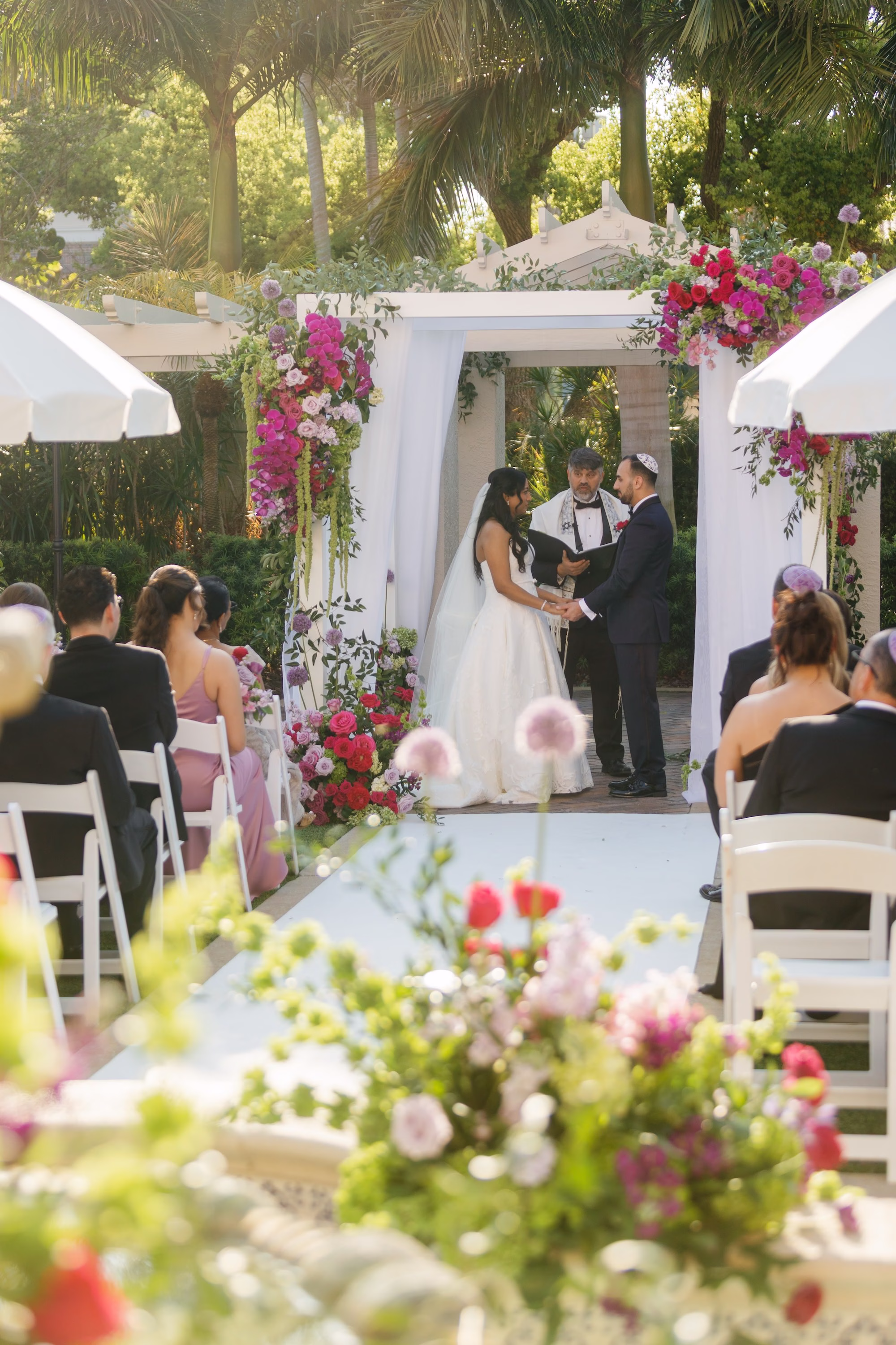 Bride and Groom Jewish Wedding Ceremony Under White Draped Chuppah with Fuchsia Orchid and Bougainvillea Florals | Tea Garden Wedding Ceremony at St. Pete Venue The Vinoy | Planner Parties A' La Carte | Florist Bruce Wayne Florals