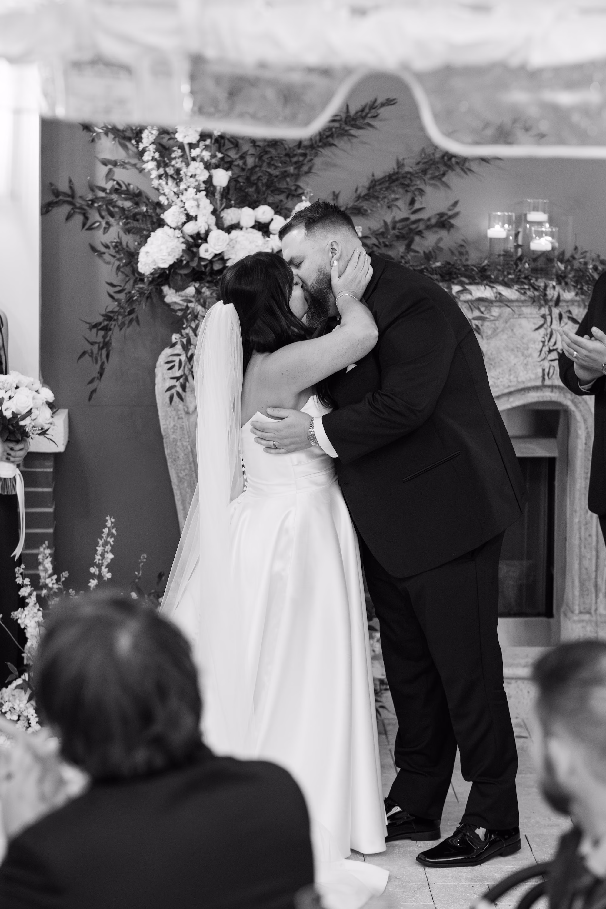 Black and White Bride and Groom First Kiss Wedding Portrait in Front of Fireplace