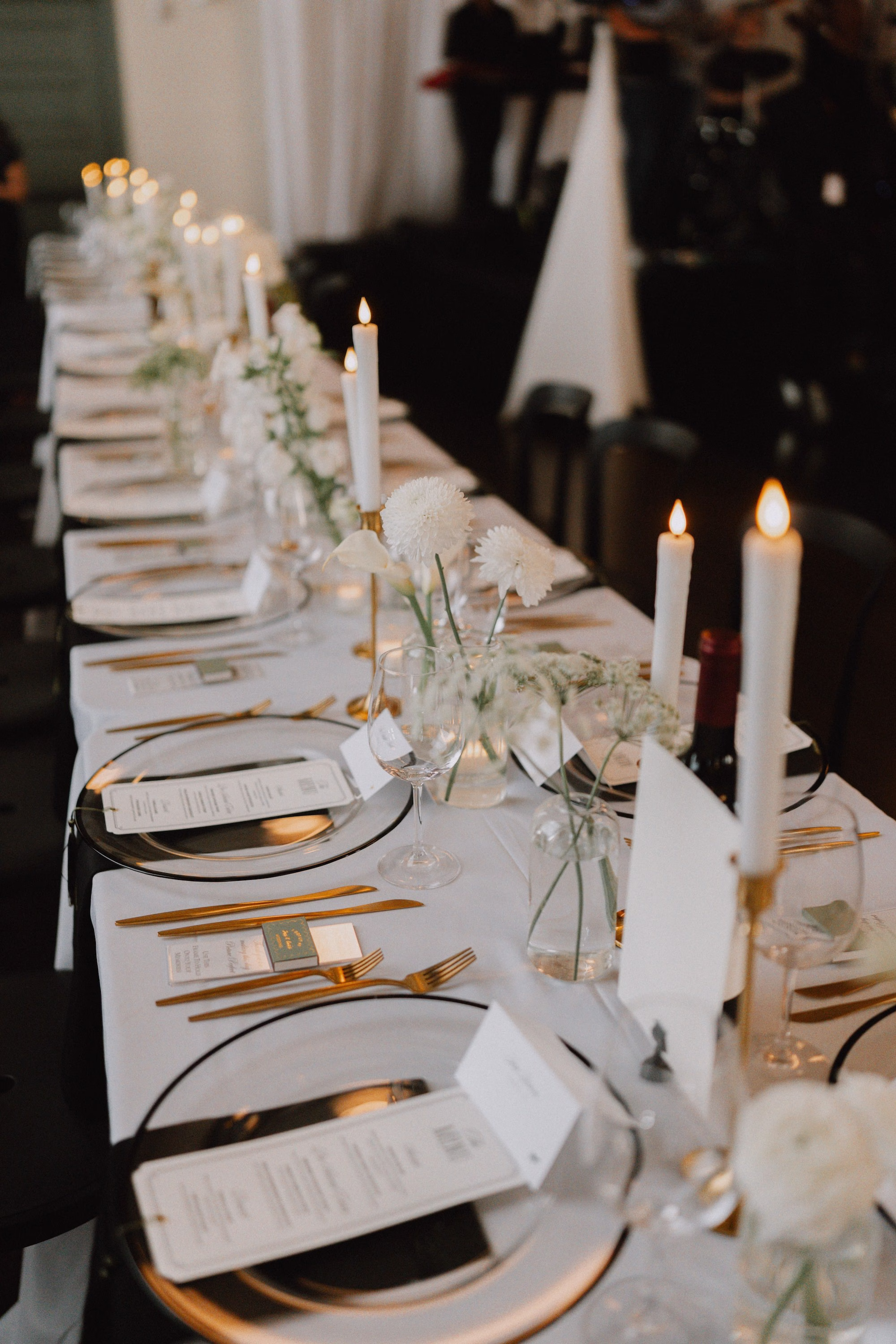 31Classic Modern Black and White Wedding Ideas - Modern Black and Ivory Ybor City Wedding | J.C. Newman Cigar Co. Long White Wedding Reception Table with Black Rimmed Chargers, Gold Flatware, Taper Candles and Menu Cards Ideas