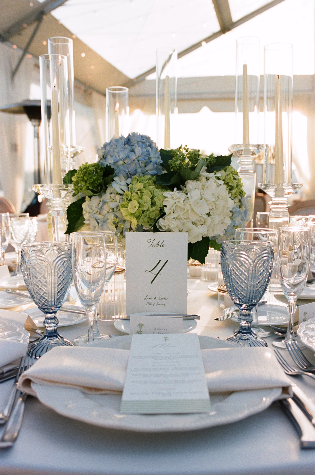33Coastal Nancy Meyers Inspired Florida Beach Wedding - Coastal Blue, White, and Green Sarasota Wedding | The Resort at Longboat Key Club Blue Cut Glass Goblets, White Menu Card, Table Number and Blue and White Hydrangea Centerpiece with Glass Taper Candle Holders Wedding Place Setting Ideas