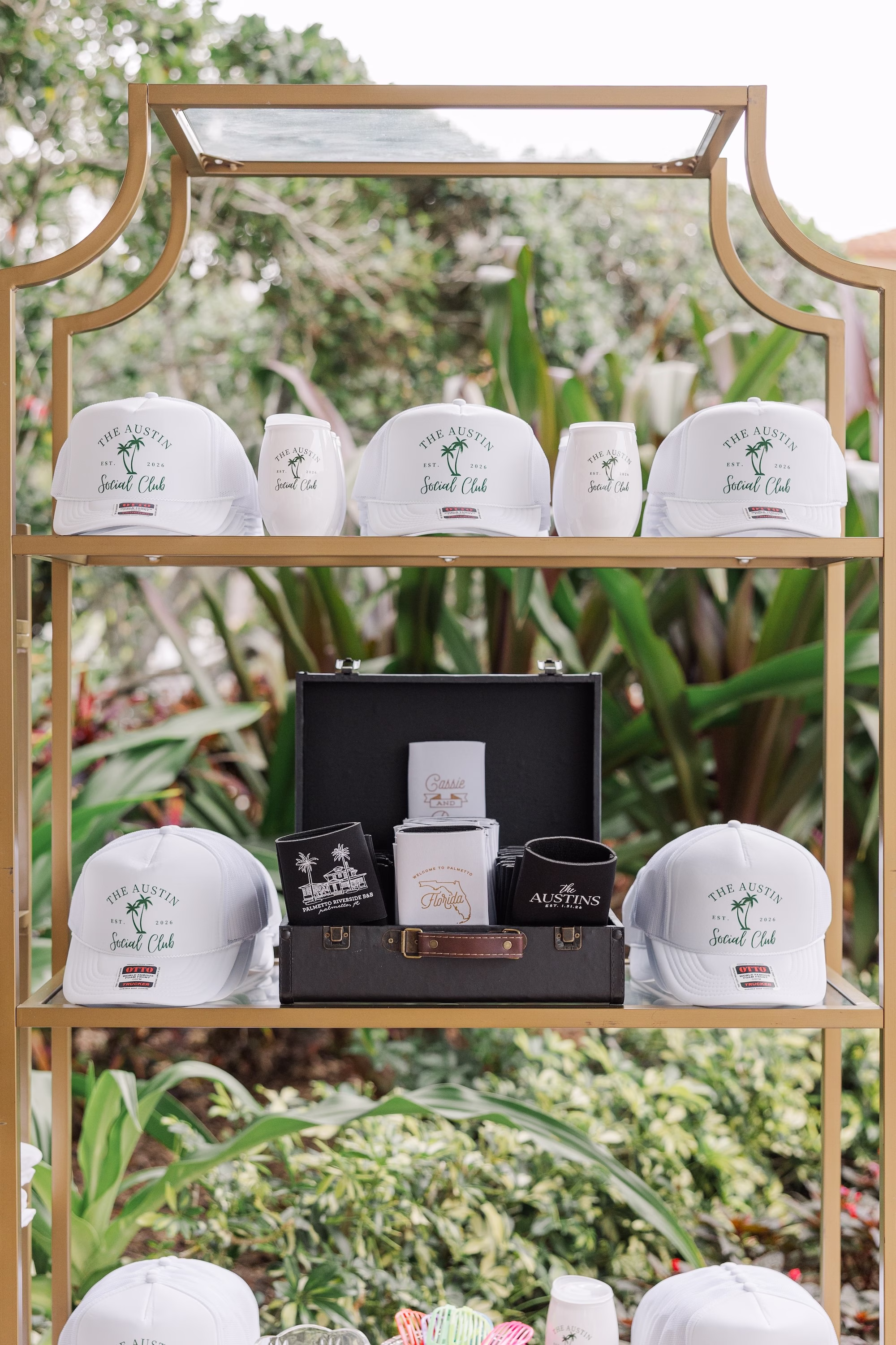 Custom The Austin Social Club Trucker Hats and Koozies in Vintage Suitcase Wedding Favor Display Ideas