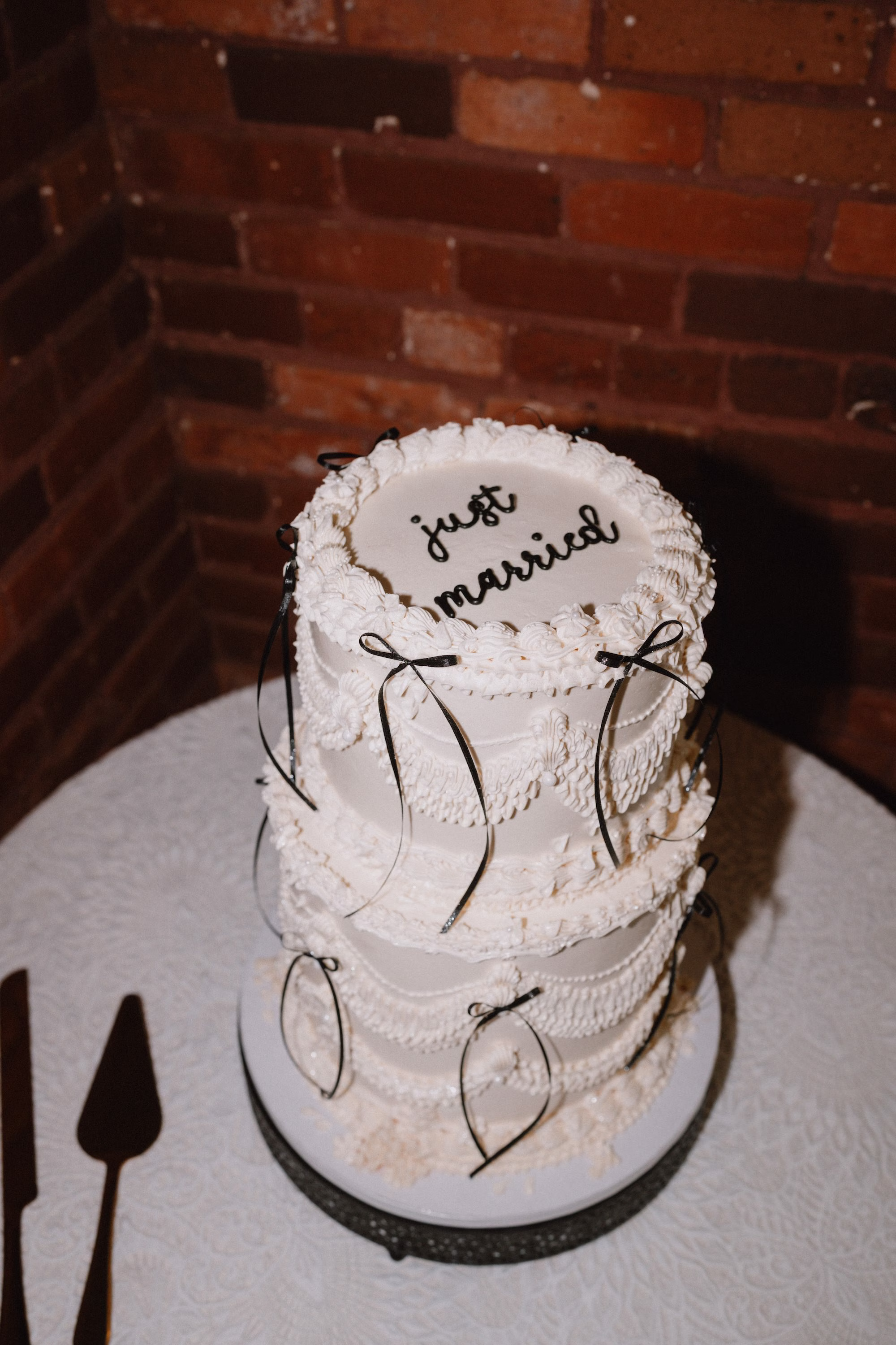 36Classic Modern Black and White Wedding Ideas - Modern Black and Ivory Ybor City Wedding | J.C. Newman Cigar Co. Vintage-Inspired White Three-Tier Wedding Cake with Piped Details, Black Bows and Just Married Script Ideas
