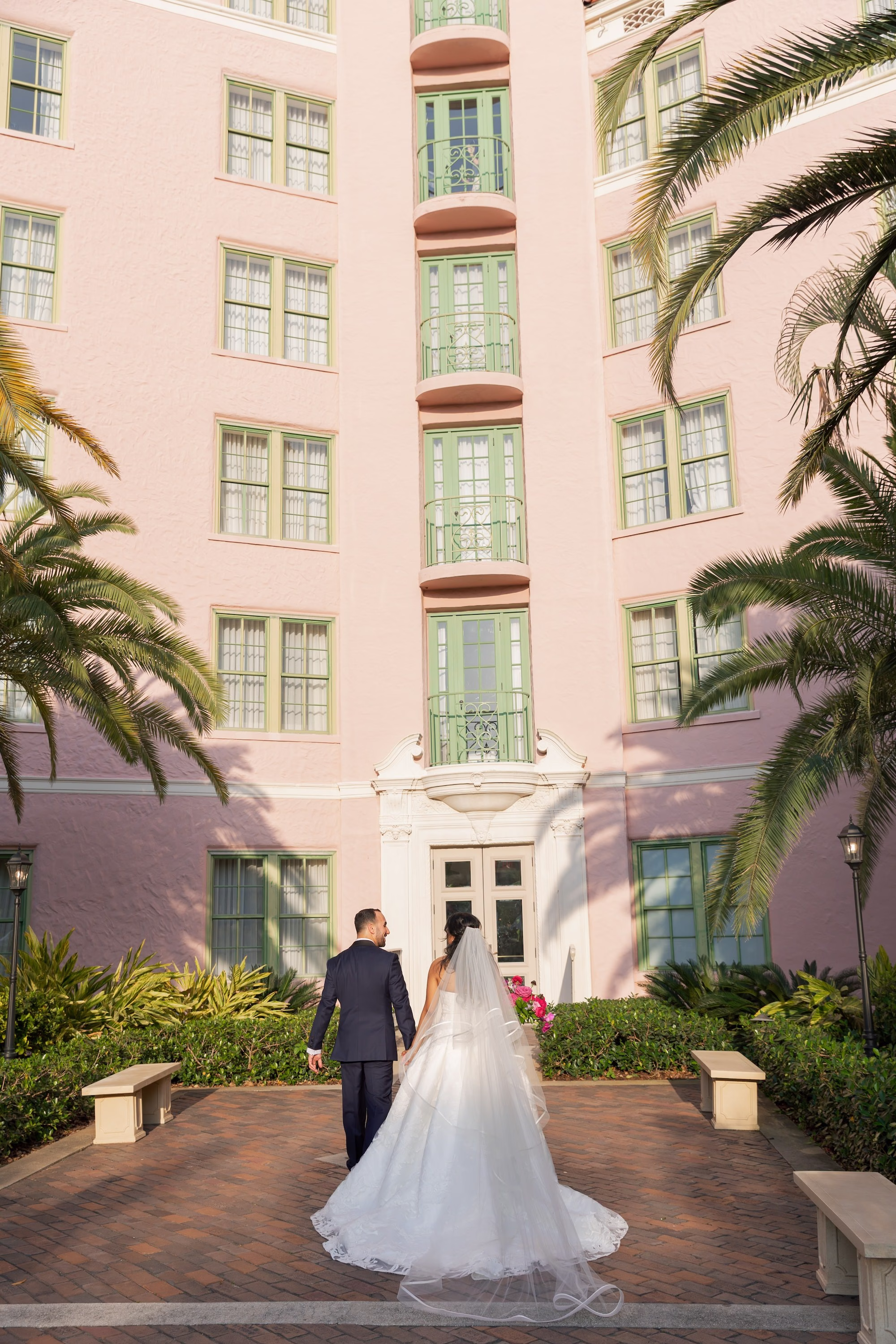 Bride and Groom Wedding Portrait in Front of Pink Mediterranean Revival Hotel | St. Pete Wedding Venue The Vinoy