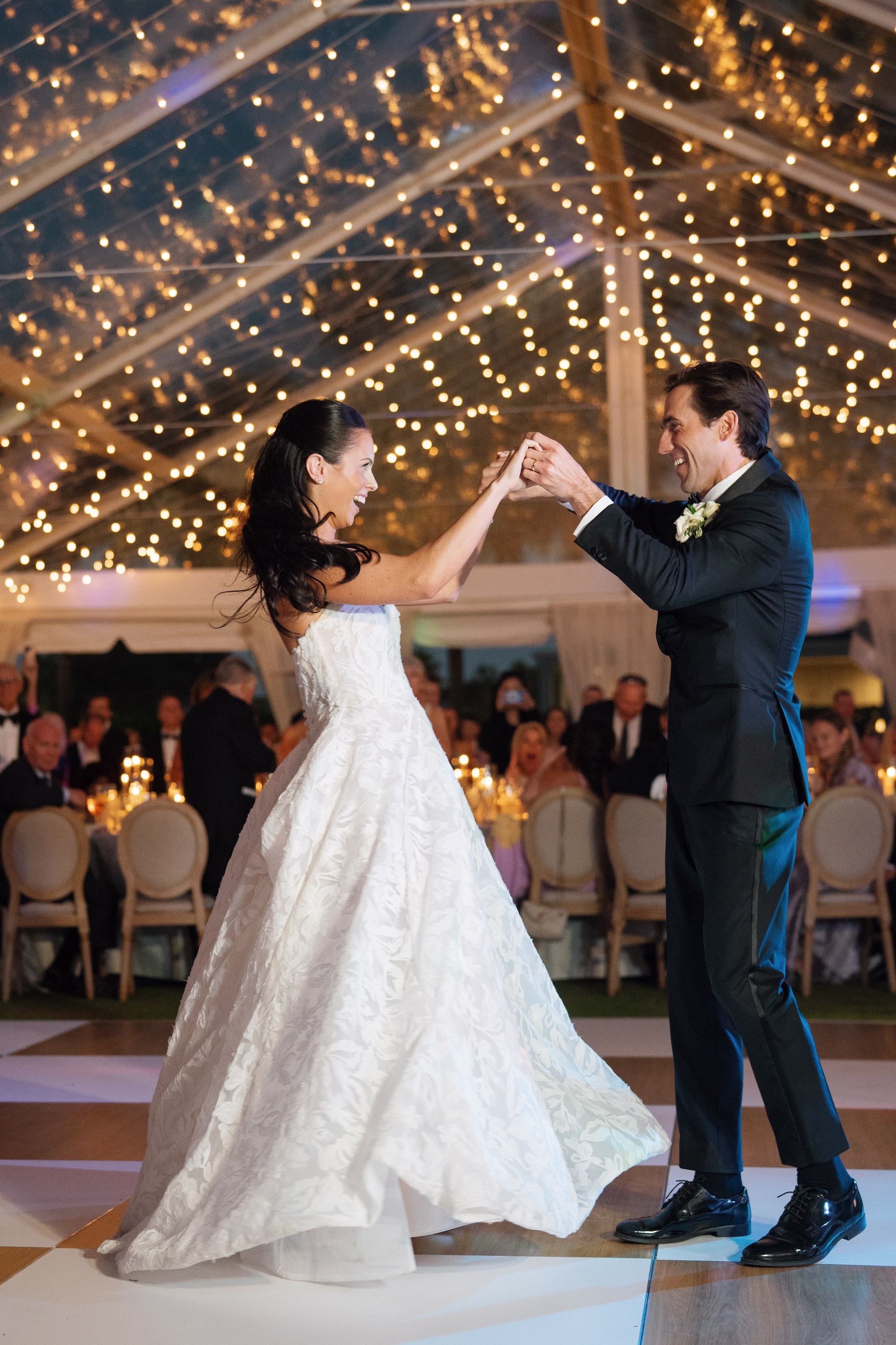 37Coastal Nancy Meyers Inspired Florida Beach Wedding - Coastal Blue, White, and Green Sarasota Wedding | The Resort at Longboat Key Club Bride and Groom First Dance Wedding Portrait Under Clear Tent with String Light Canopy | Tented Lawn Wedding Reception